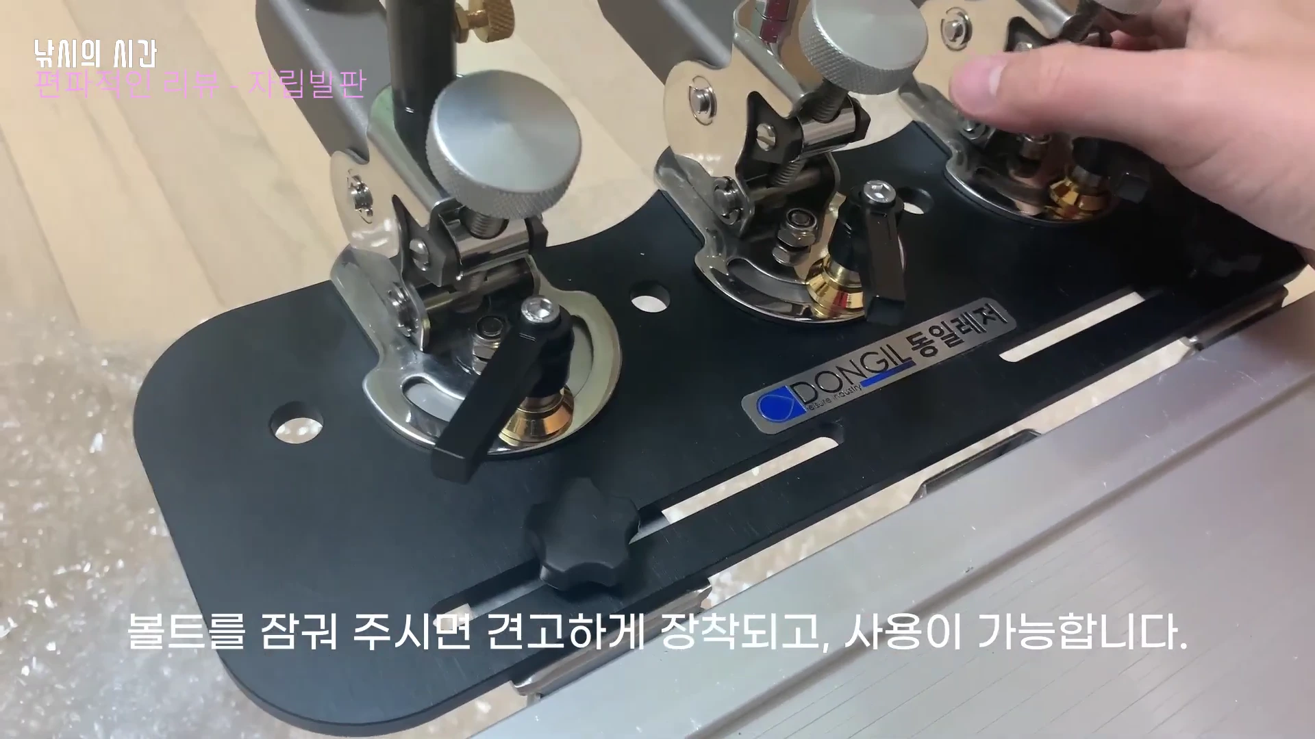 낚시용 자립발판에 3단 받침틀을 조립하고 손으로 볼트를 조이는 모습
