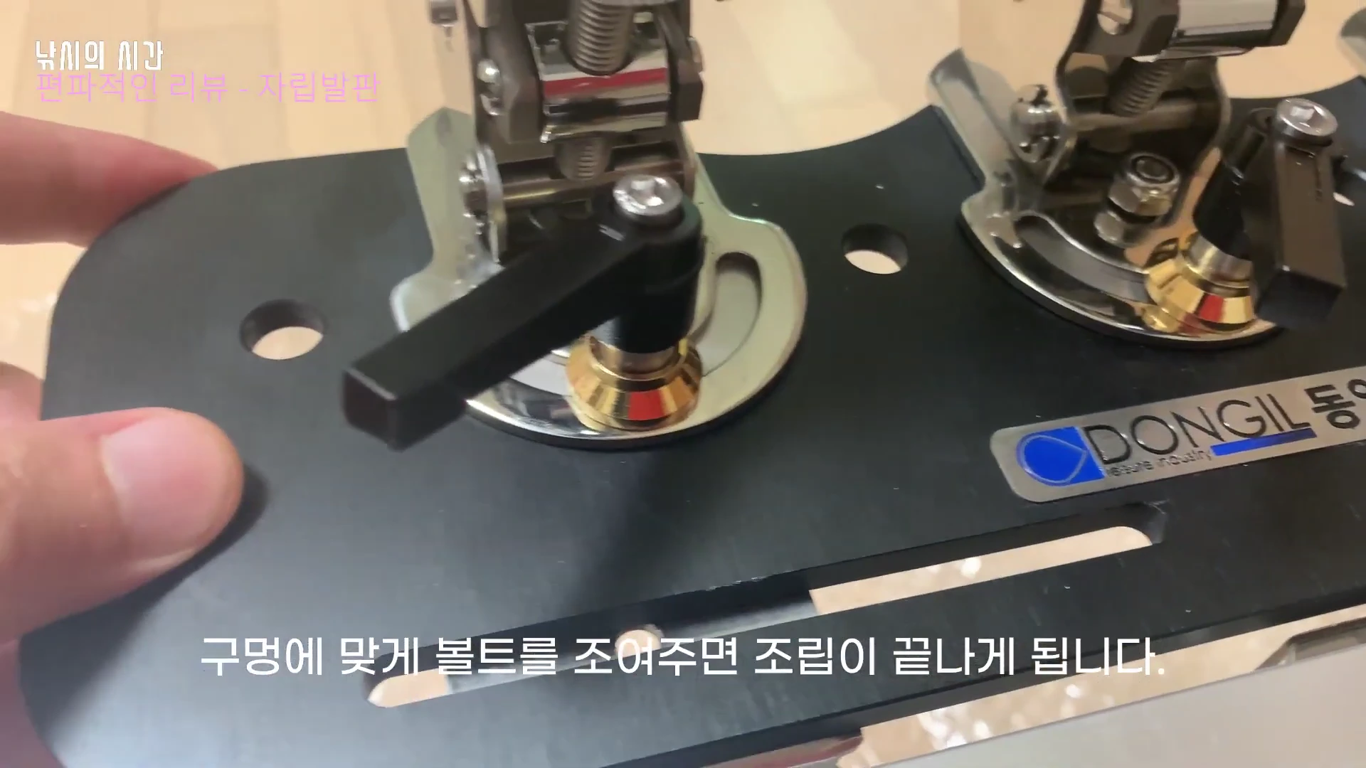 낚시 장비의 부품을 손으로 잡고 볼트를 조여 고정하는 모습