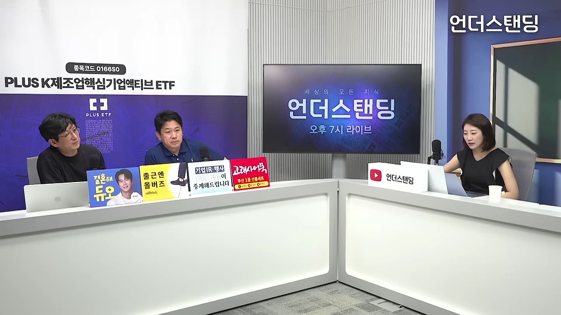 스튜디오에 앉아 대화를 나누는 세 명의 출연자와 대형 화면이 보이는 방송 장면