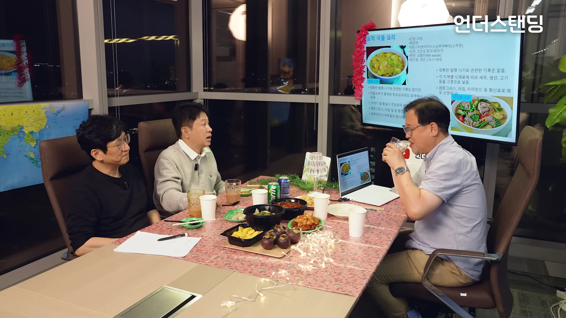 스튜디오 테이블에 앉아 대화하는 세 명의 남성과 뒤편의 똠얌꿍, 시니강 정보가 담긴 화면