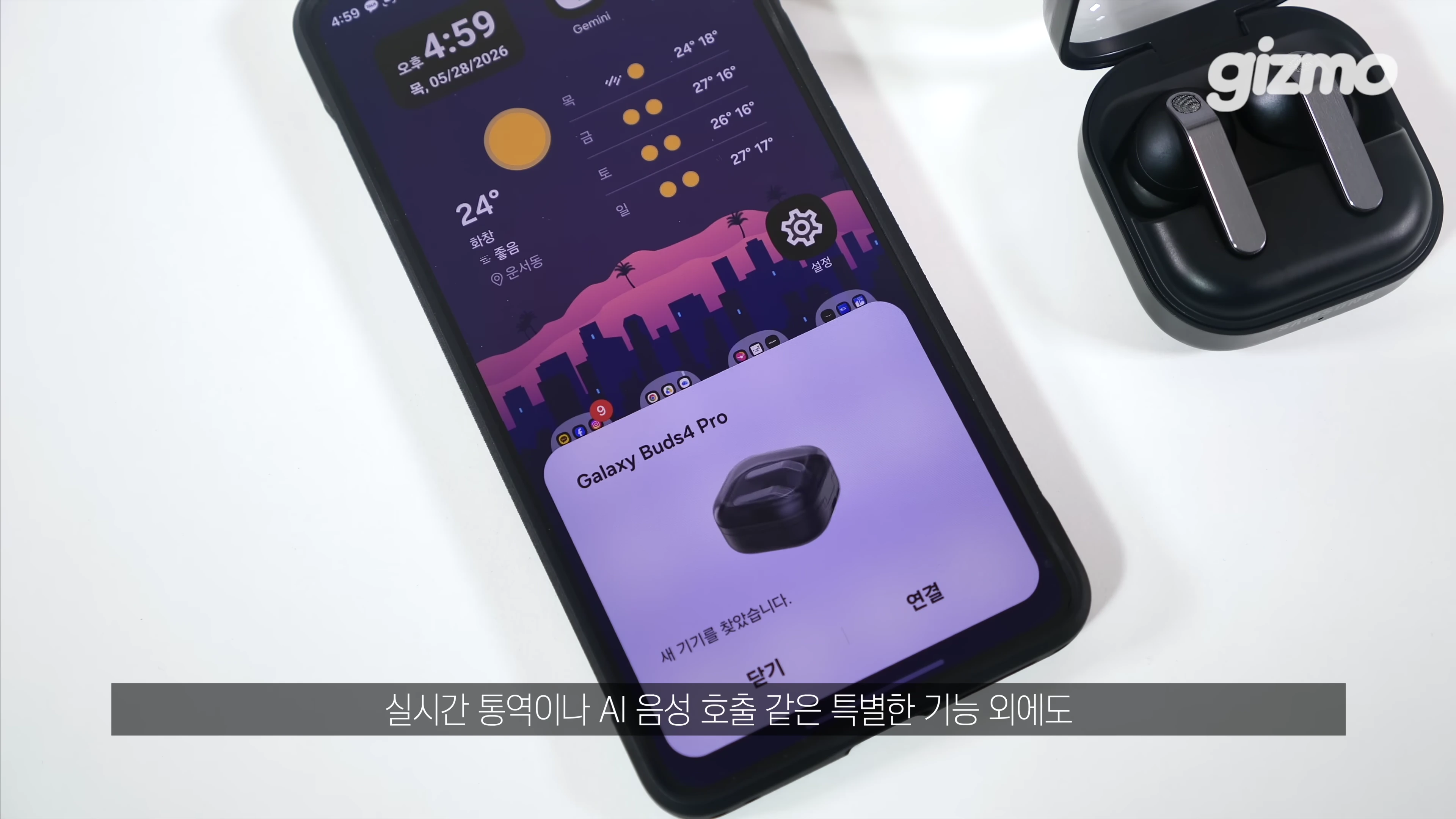 스마트폰 화면에 갤럭시 버즈4 프로 연결 팝업창이 떠 있고 옆에 이어폰 케이스가 놓여 있다.