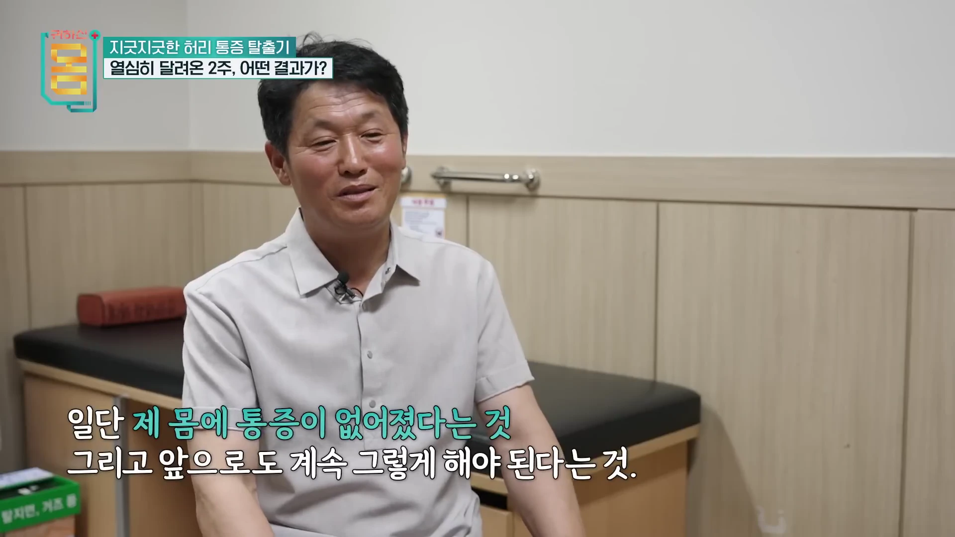 밝은 셔츠를 입은 중년 남성이 실내에서 인터뷰하며 미소 짓고 있고, 화면 하단에는 자막이 배치되어 있다.
