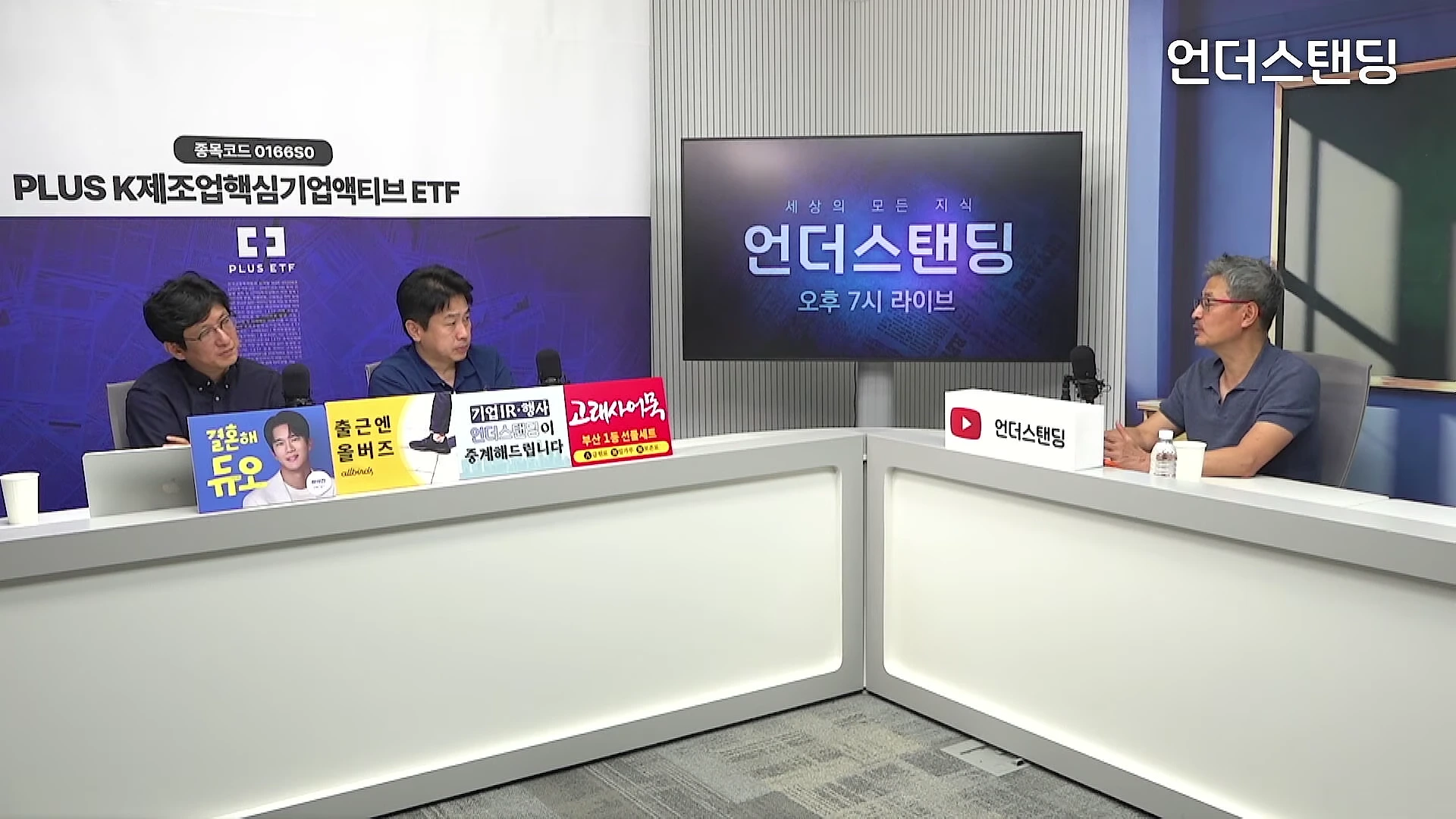 스튜디오에서 세 명의 남성이 테이블을 사이에 두고 대화를 나누는 모습