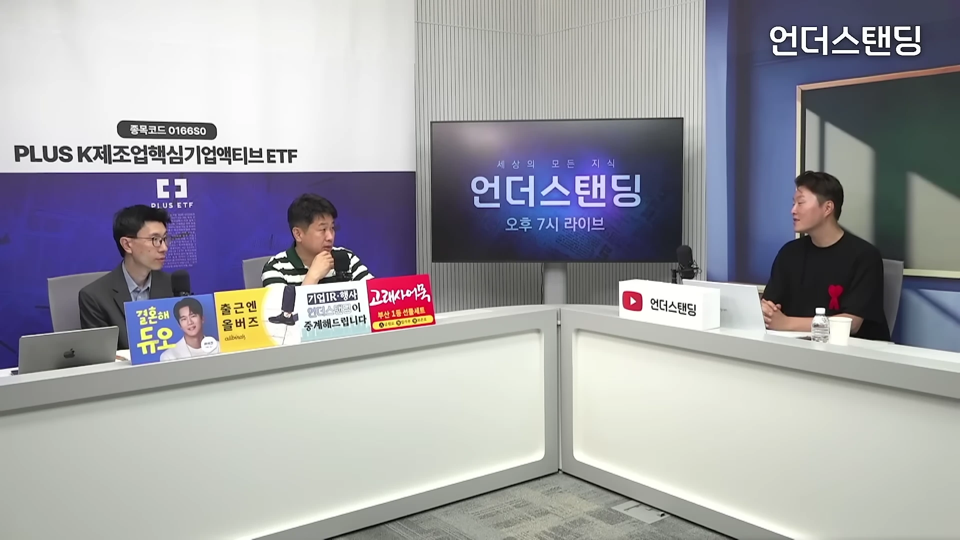 스튜디오에서 세 명의 남성이 테이블에 앉아 대화를 나누고 있는 모습