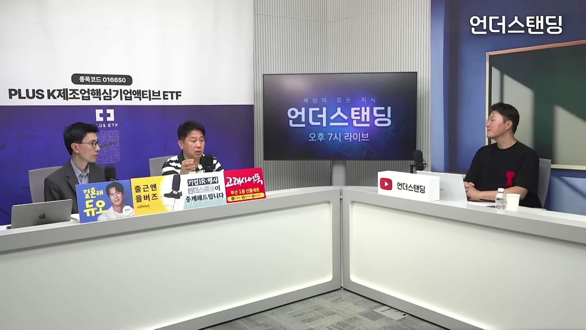 스튜디오에서 세 명의 남성이 테이블에 앉아 대화를 나누고 있는 모습