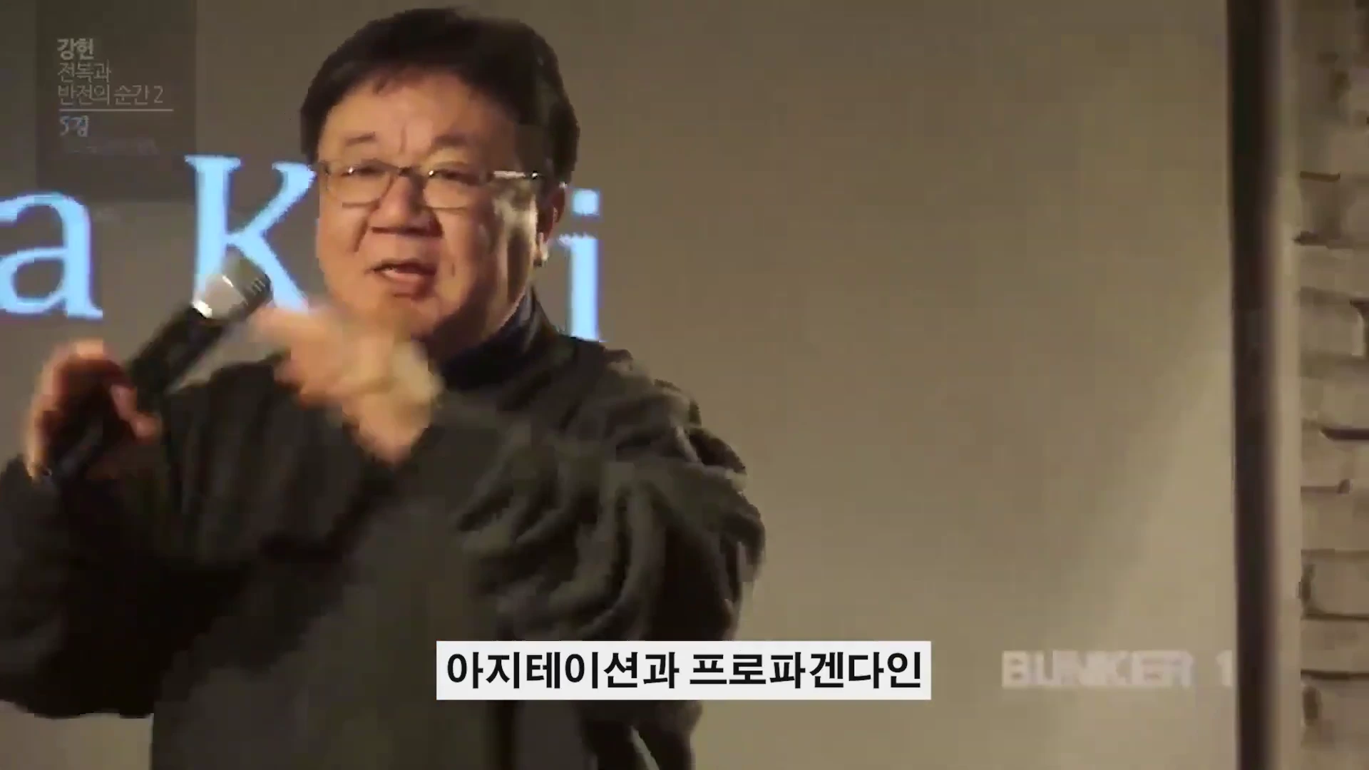 안경을 쓴 중년 남성이 마이크를 들고 강연하는 모습이 담긴 영상 캡처 화면