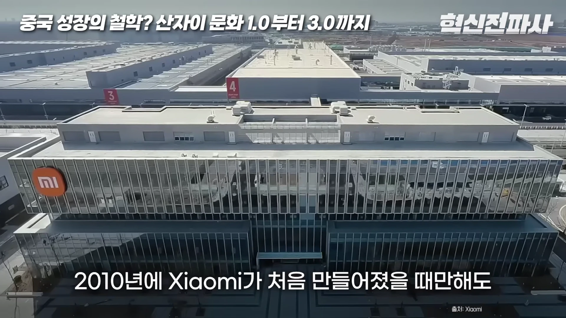 샤오미 로고가 부착된 현대적인 대형 공장 건물을 위에서 내려다본 항공 촬영 화면