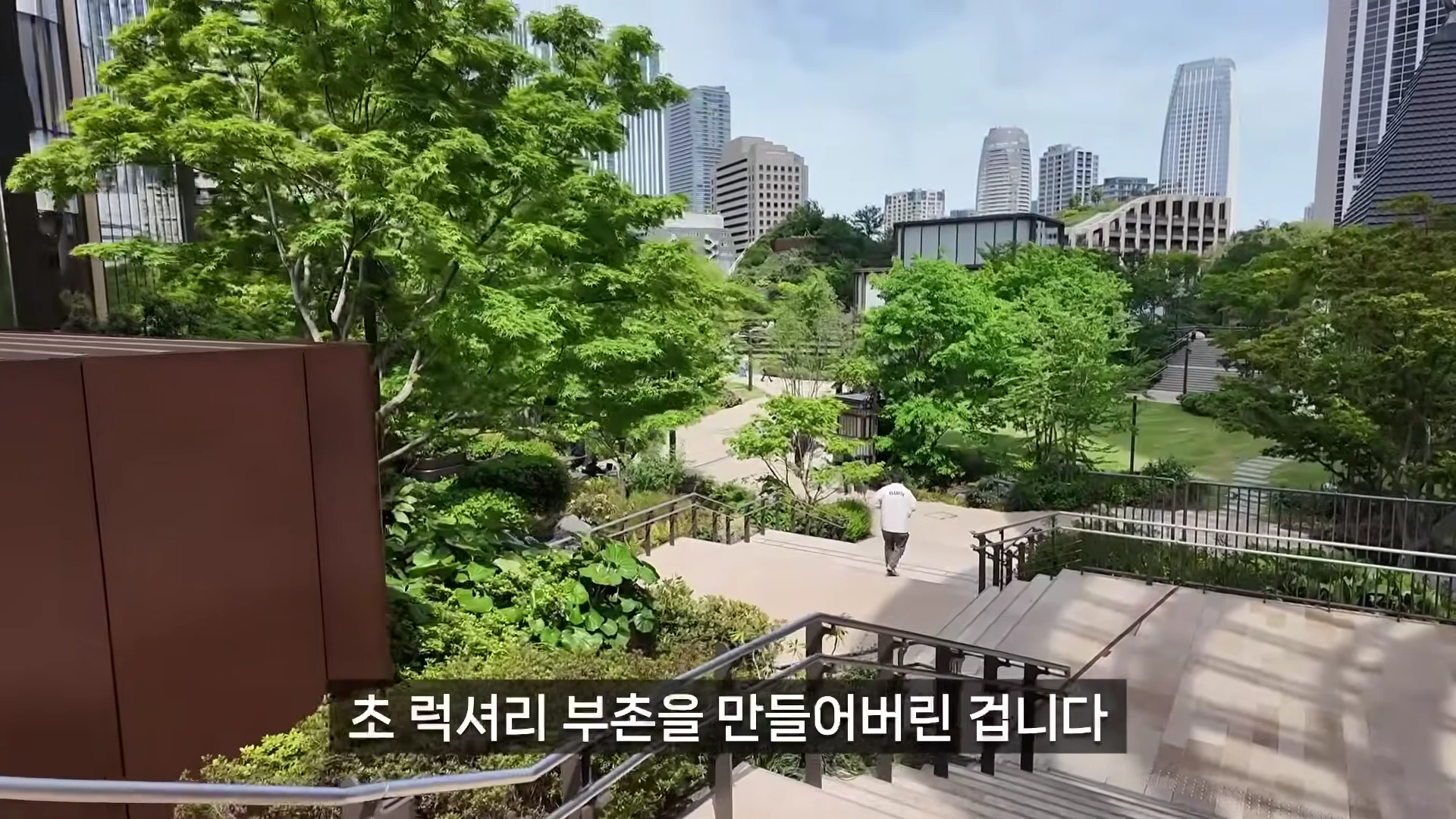 도심 속 녹지가 조성된 아자부다이 힐즈의 야외 정원과 계단을 걷는 사람의 모습