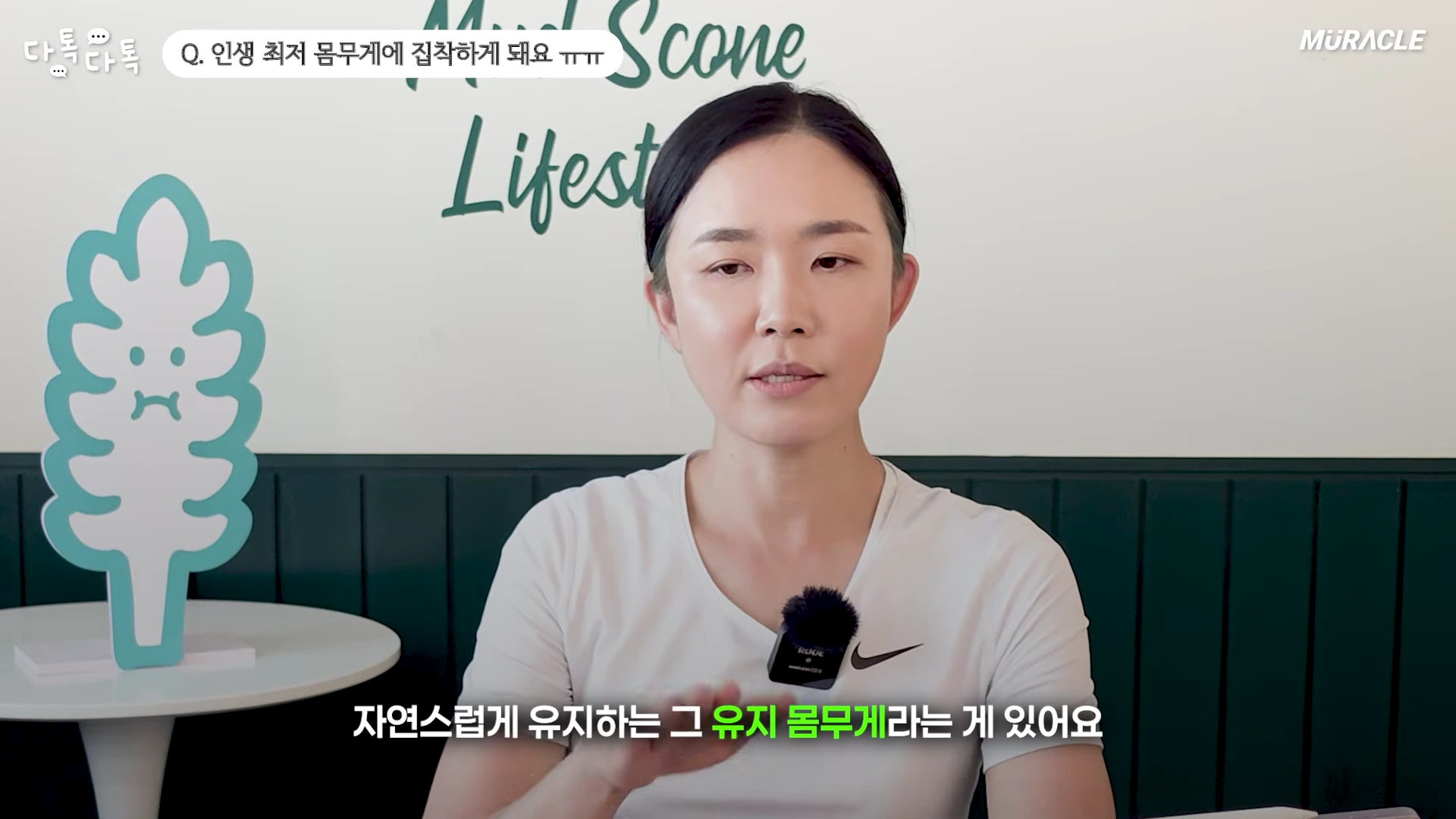흰색 티셔츠를 입은 여성이 스튜디오에서 다이어트 고민에 대해 이야기하고 있다.