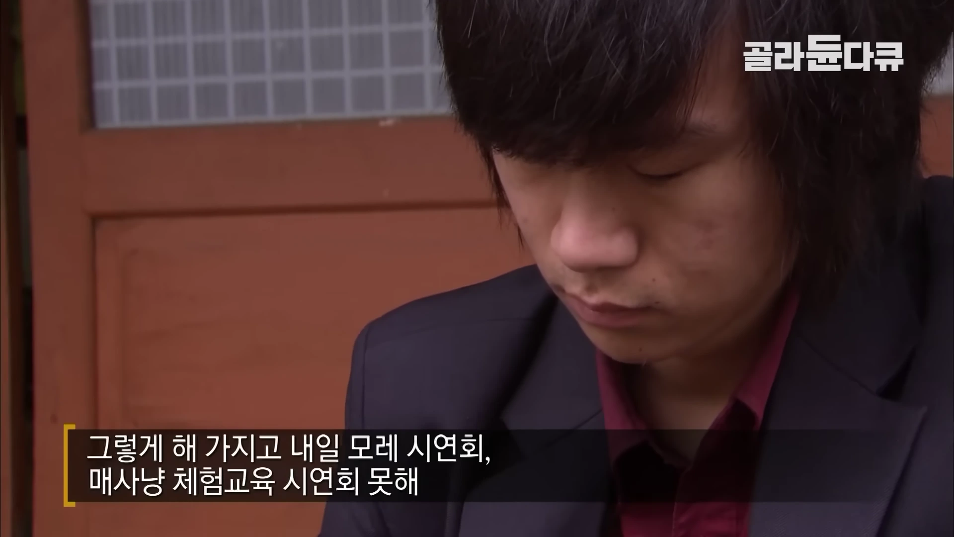 고개를 숙인 채 고민에 잠긴 젊은 남성의 얼굴이 담긴 다큐멘터리 영상 화면
