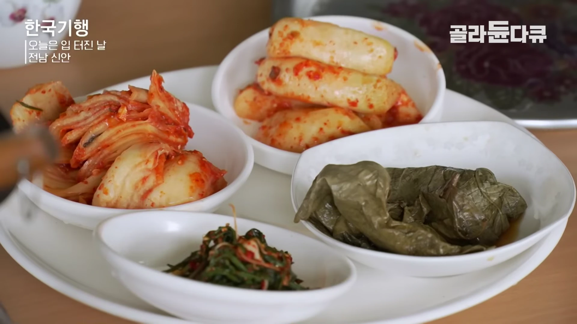 흰 접시에 담긴 김치, 깍두기, 나물 등 소박한 밑반찬들이 놓인 식탁 모습