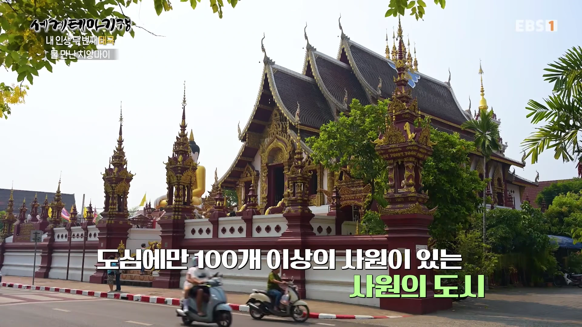 태국 치앙마이의 화려한 전통 양식 사원과 그 앞을 지나가는 오토바이들