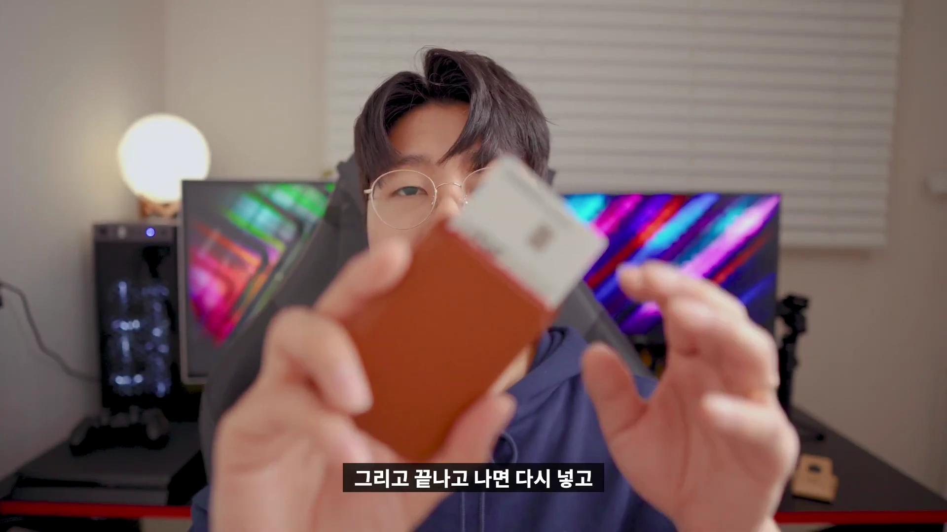 안경을 쓴 남성이 맥세이프 카드지갑에서 카드를 살짝 꺼내 보여주고 있다.