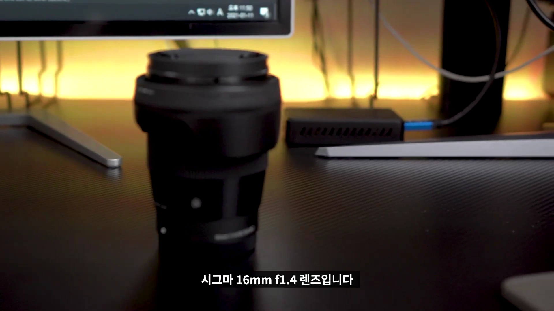 책상 위에 놓인 시그마 16mm f1.4 단렌즈의 모습