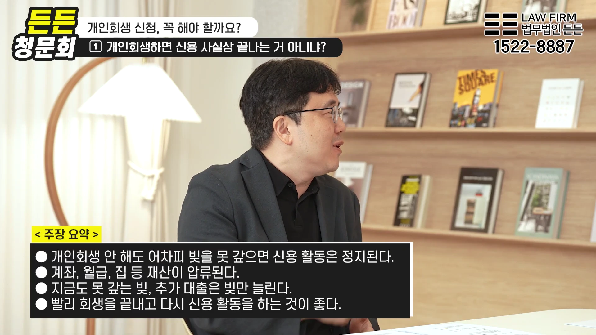 안경을 쓴 남성이 사무실 배경에서 개인회생에 대한 주장이 담긴 자막이 포함된 영상을 촬영하고 있다.