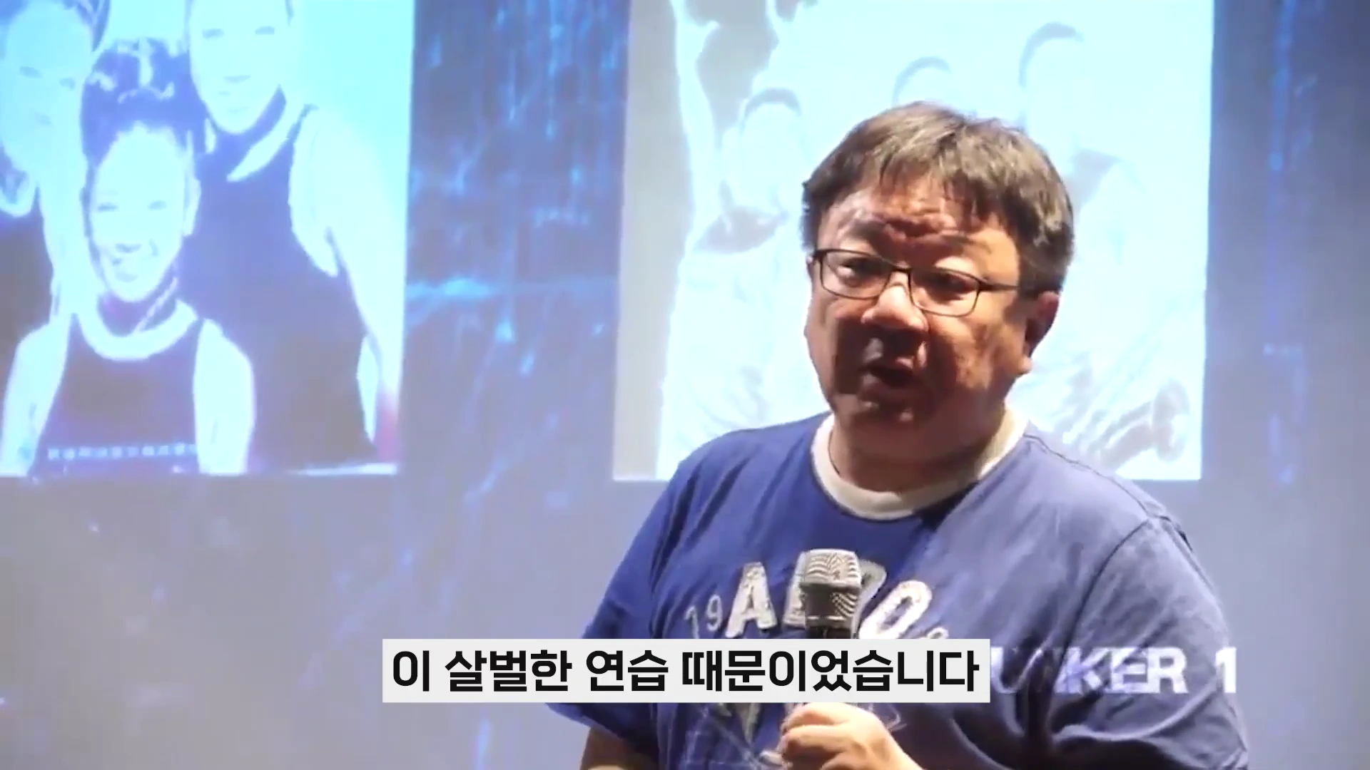 안경을 쓴 중년 남성이 마이크를 잡고 강연하는 모습과 뒤편 스크린에 흑백 사진이 비치는 장면