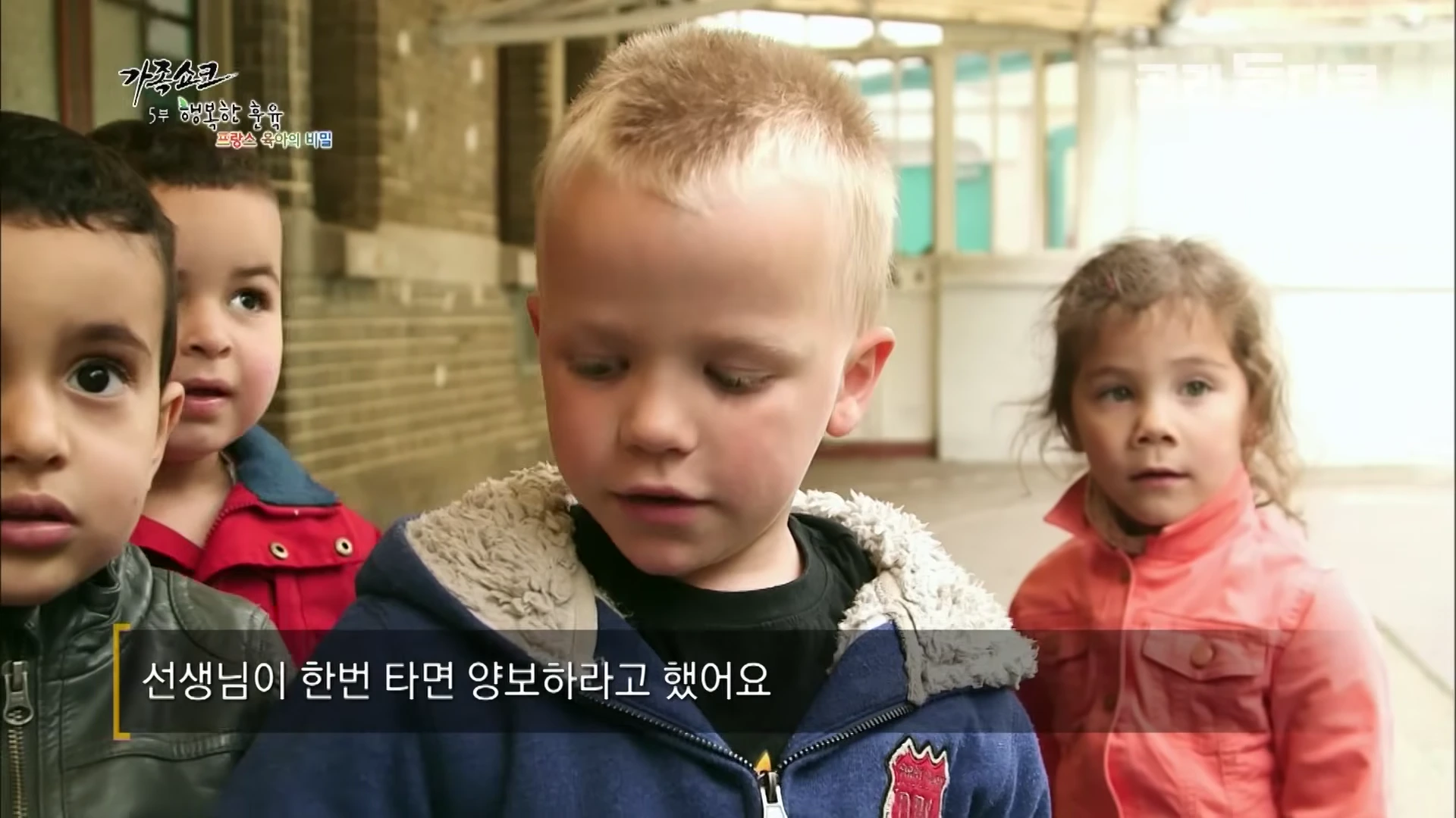 야외에서 자전거를 타는 아이들과 그 주변에 서 있는 아이들의 모습이 담긴 영상 캡처 화면
