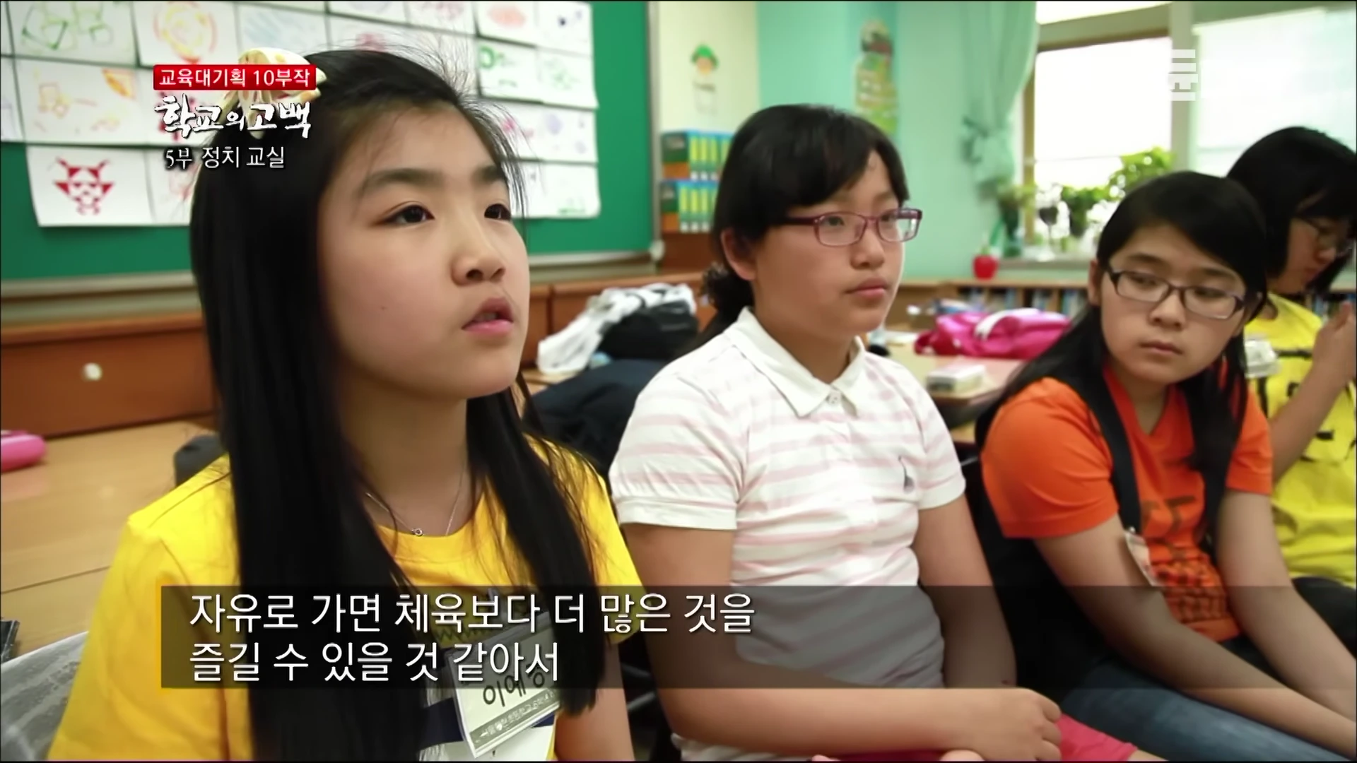 교실에 앉아 진지한 표정으로 대화에 참여하고 있는 초등학생들