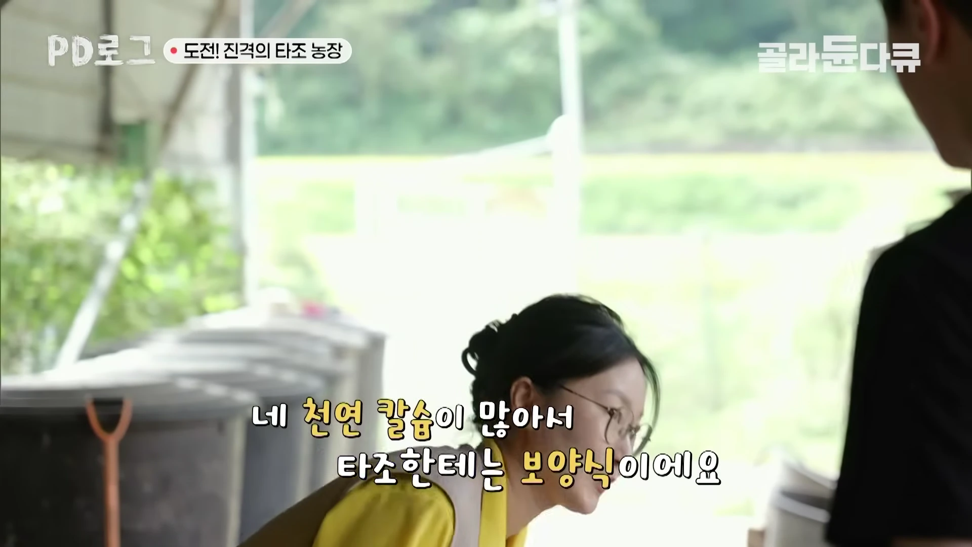 농장에서 안경을 쓴 여성이 타조알에 대해 설명하고 있는 모습