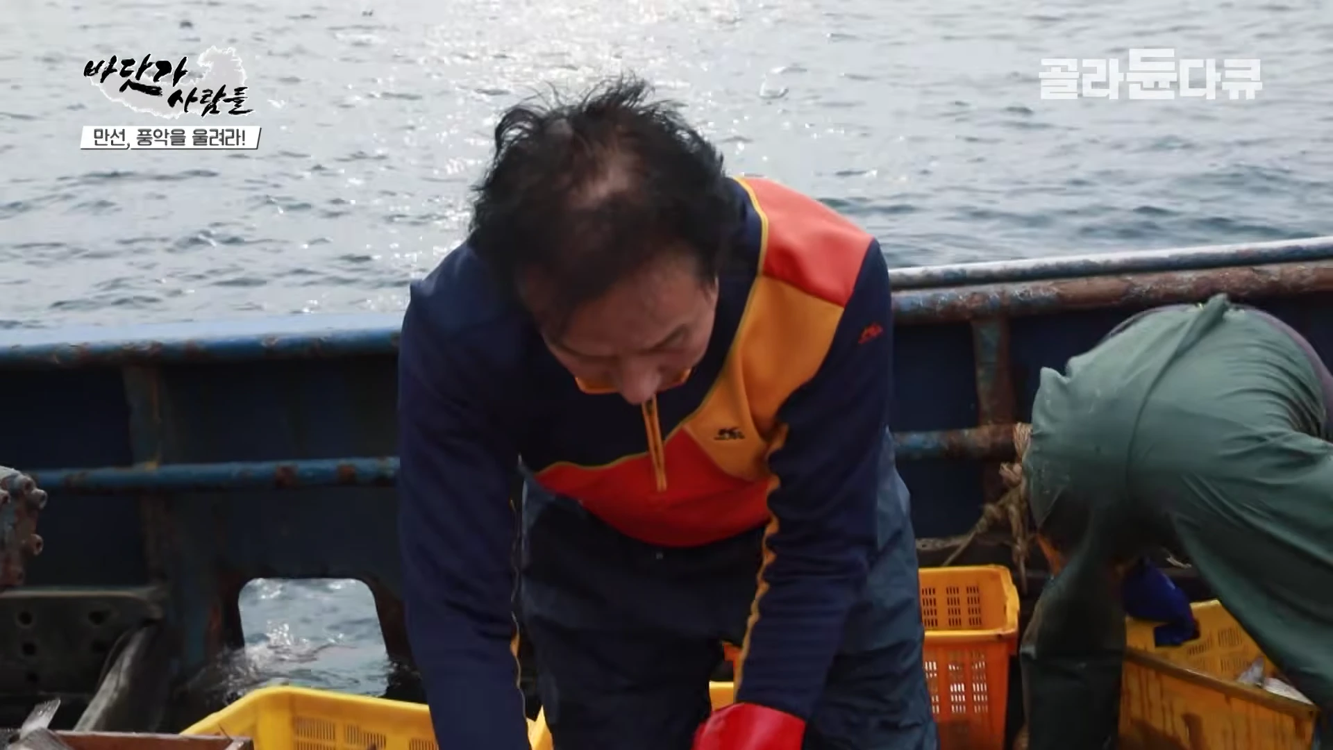 어선 갑판 위에서 작업복을 입은 선원이 가자미를 크기별로 분류하고 있다.