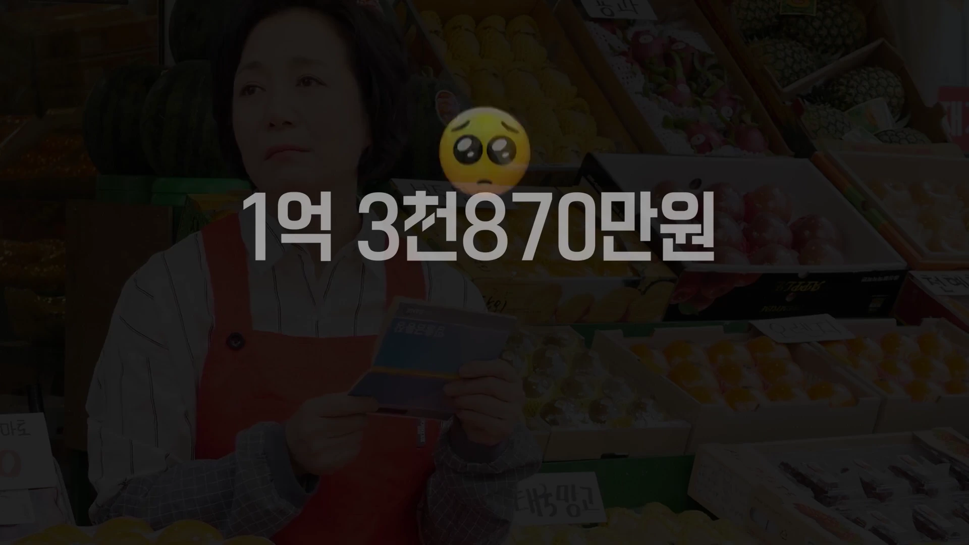 과일 가게에서 앞치마를 두른 여성이 서류를 들고 고민하는 모습과 '1억 3천 870만원'이라는 큰 글씨가 화면 중앙에 배치된 영상 캡처 화면.