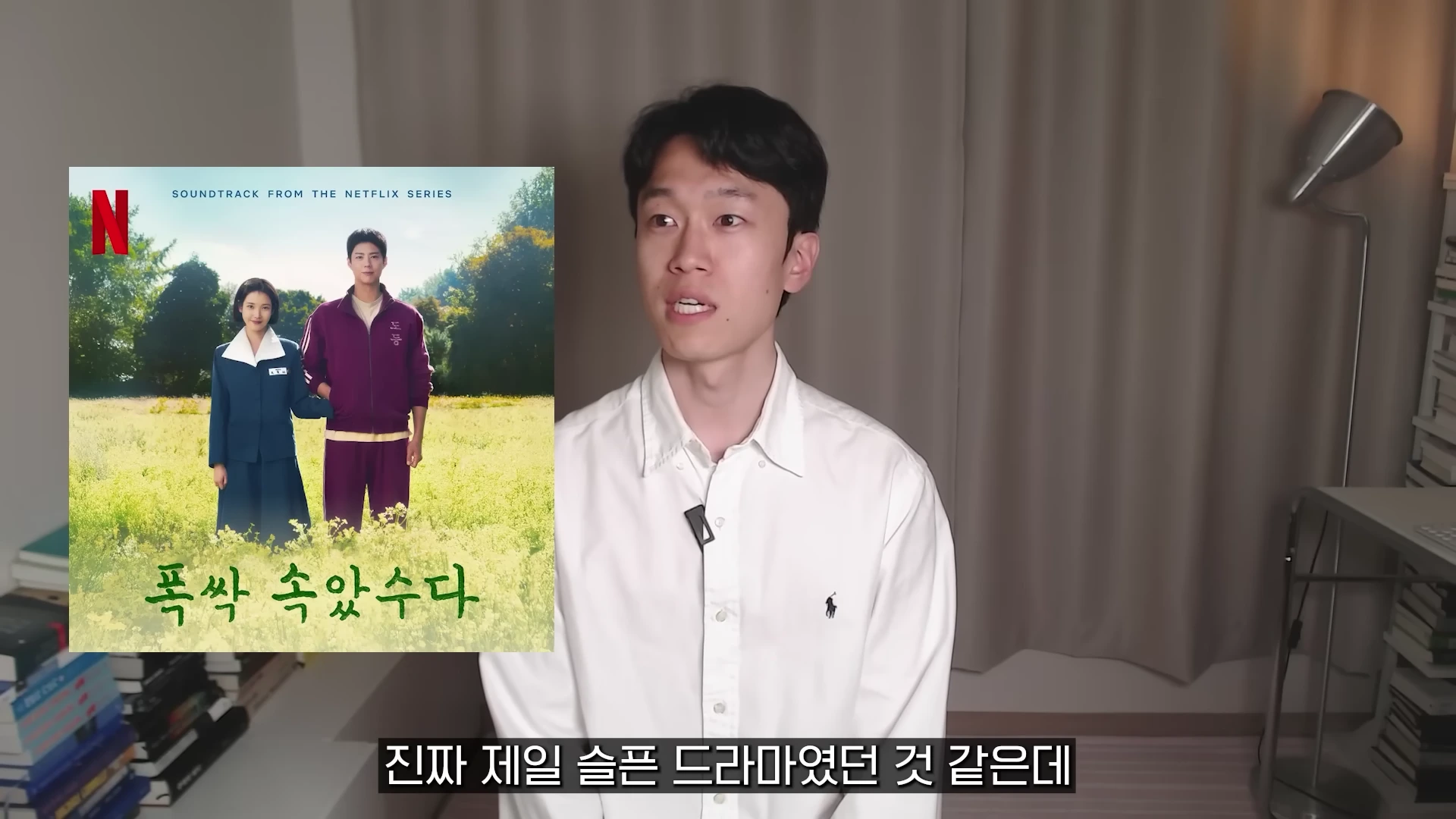 흰 셔츠를 입은 남성이 카메라를 보며 이야기하고 있고, 화면 왼쪽에는 드라마 포스터가 삽입되어 있습니다.