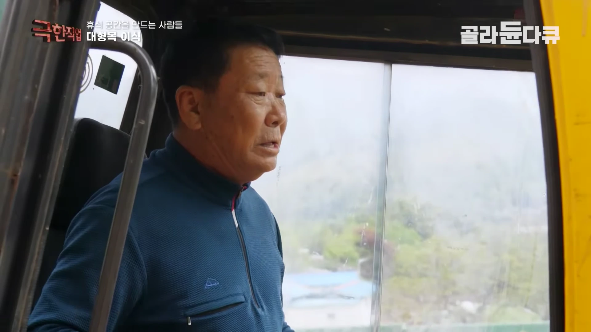 굴착기 운전석에 앉아 밖을 응시하며 작업 지시를 내리는 중년 남성