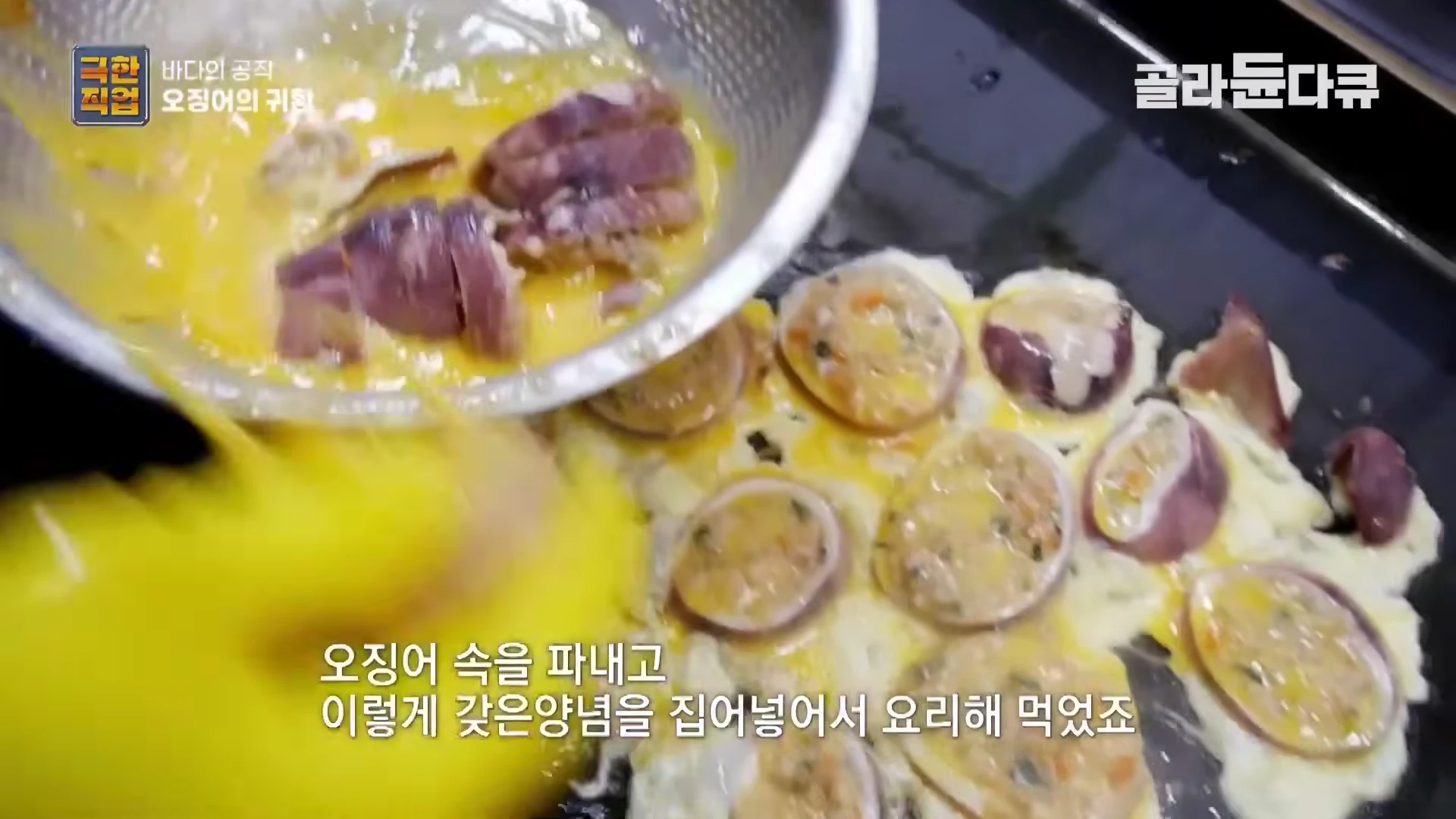 철판 위에서 계란물을 입힌 오징어순대가 노릇하게 구워지고 있는 모습