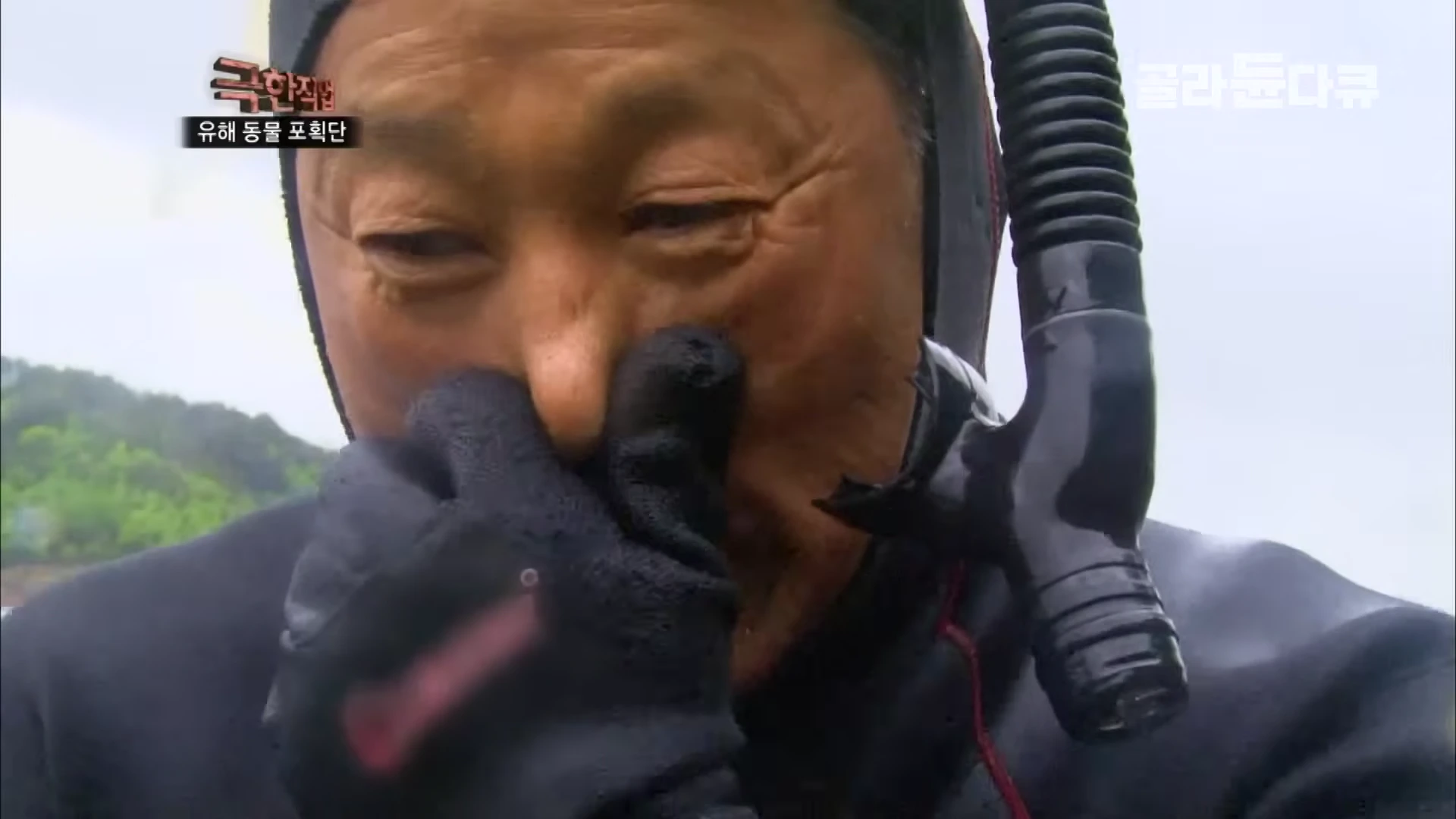 잠수복을 입고 스노클을 착용한 작업자가 코를 잡고 이퀄라이징을 하는 모습
