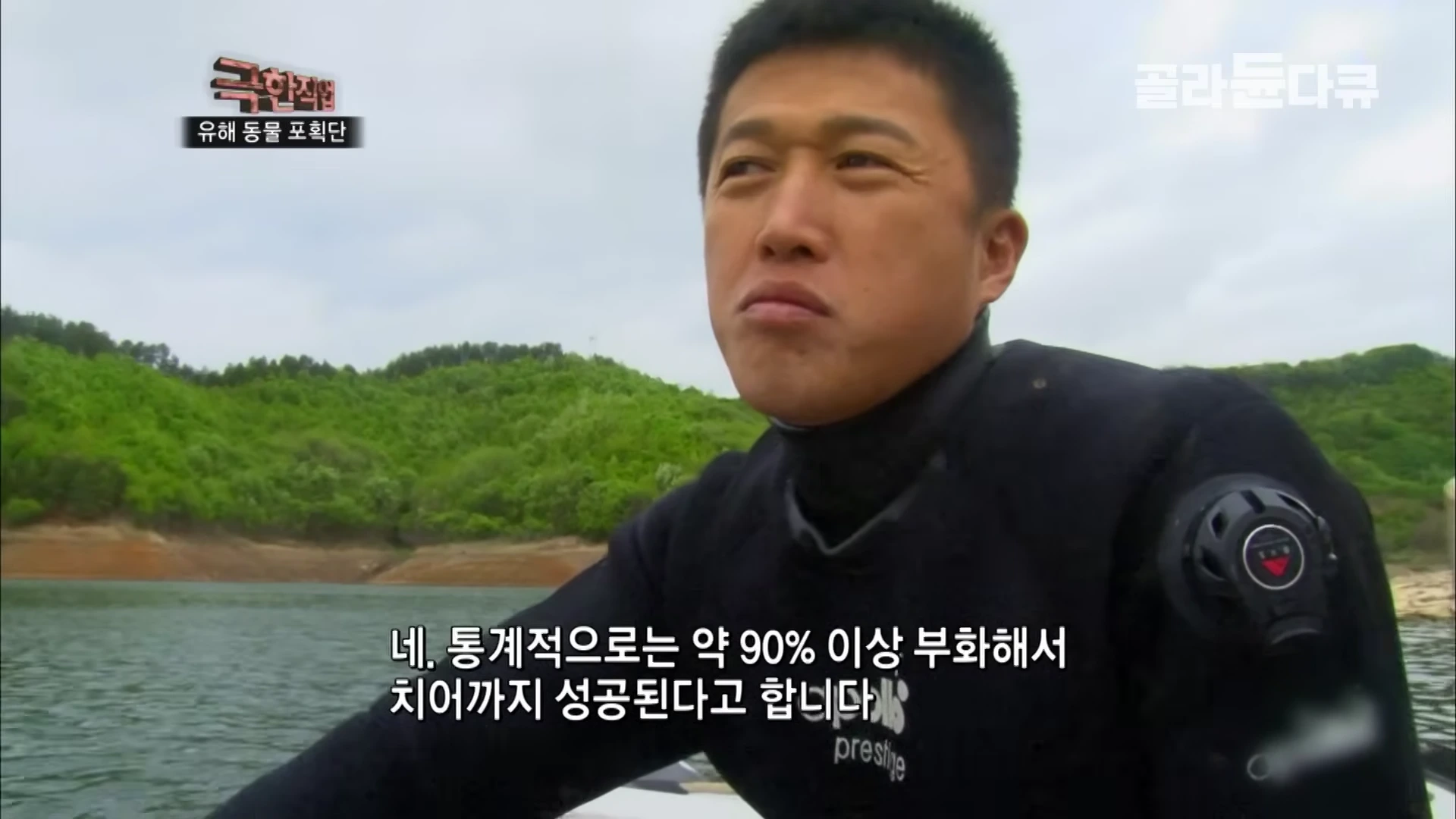 잠수복을 입은 남성이 호수 위 보트에서 인터뷰하는 모습