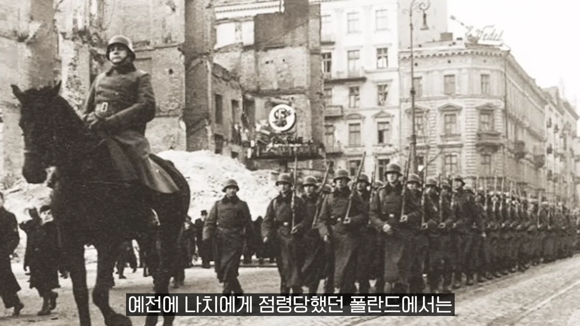 제복을 입고 말을 탄 군인과 그 뒤를 따라 행진하는 독일군 병사들의 흑백 사진