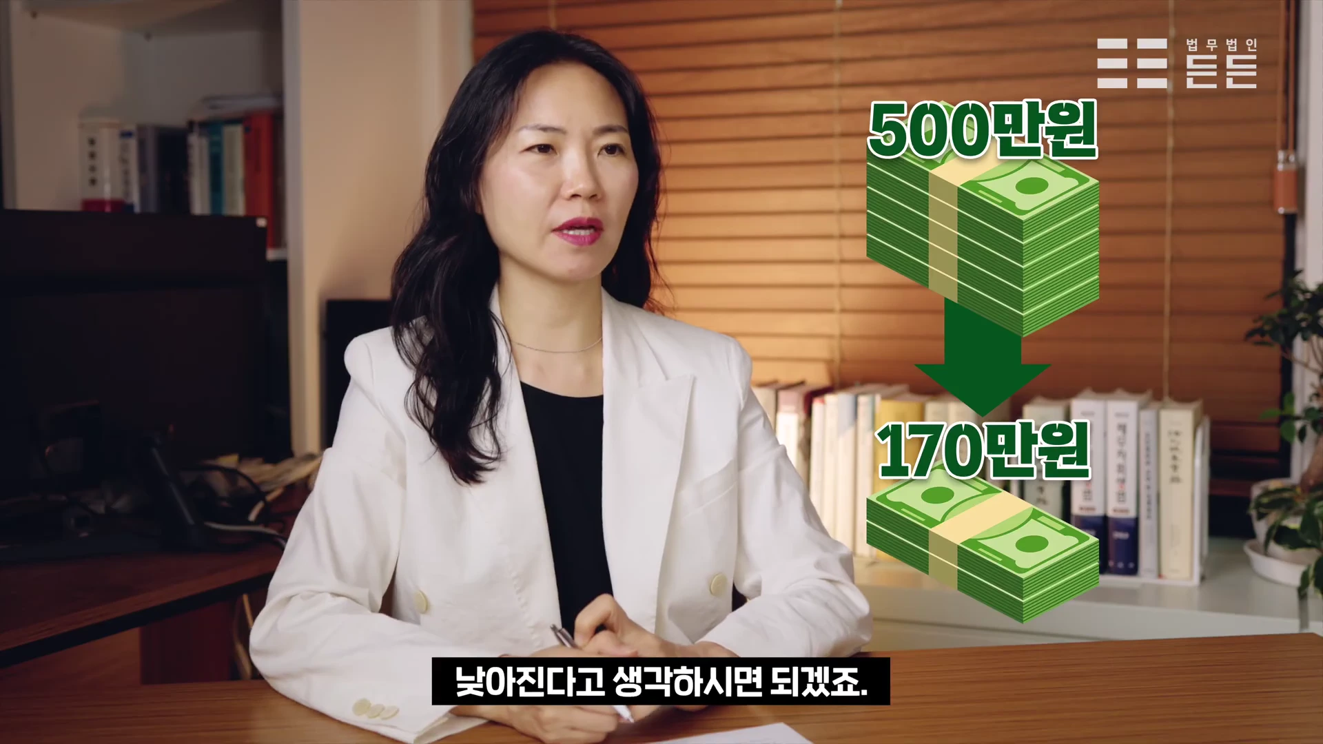 사무실에서 흰색 재킷을 입은 여성이 월 변제금 변화를 보여주는 그래픽 옆에서 설명하고 있다.