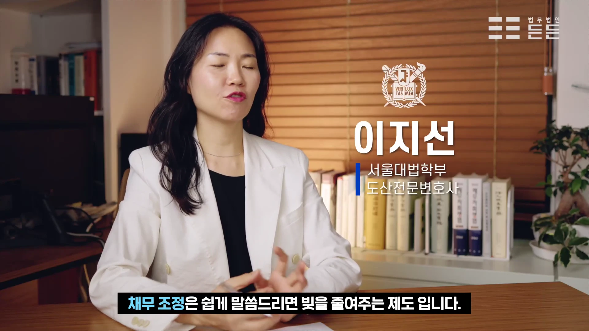흰색 재킷을 입은 변호사가 사무실에서 인터뷰하는 모습