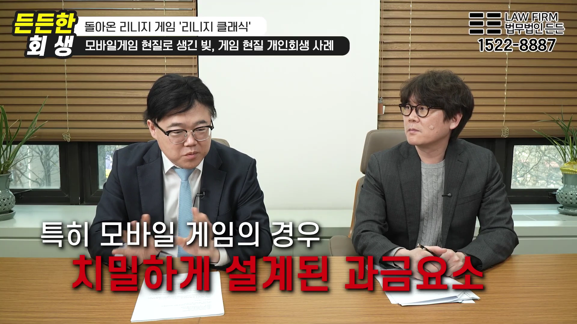 사무실 책상에 앉아 대화를 나누는 두 명의 남성 변호사와 화면 상단 및 하단에 표시된 자막