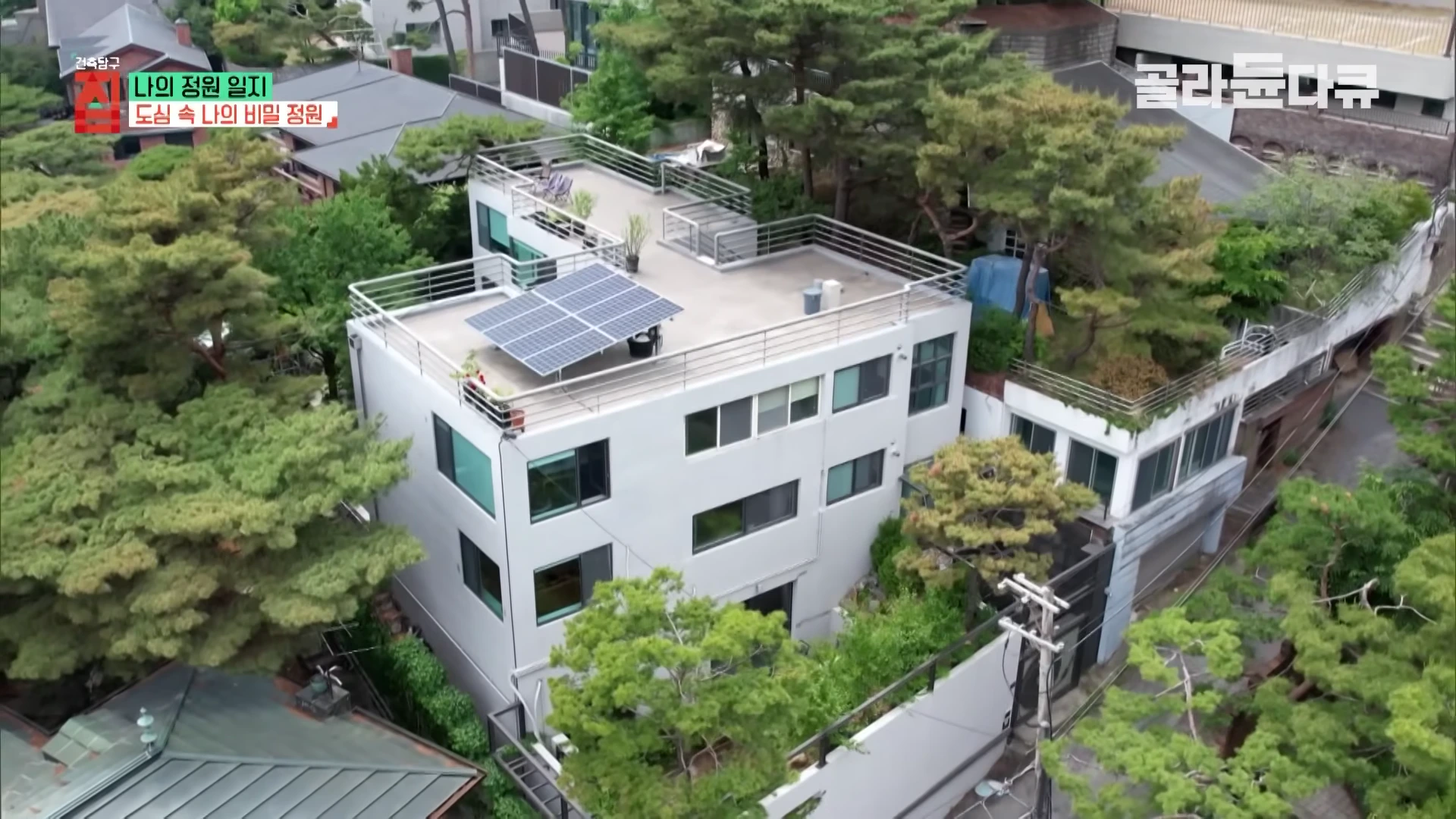 평창동의 경사진 지형에 자리 잡은 현대적인 단독주택을 위에서 내려다본 항공 뷰.