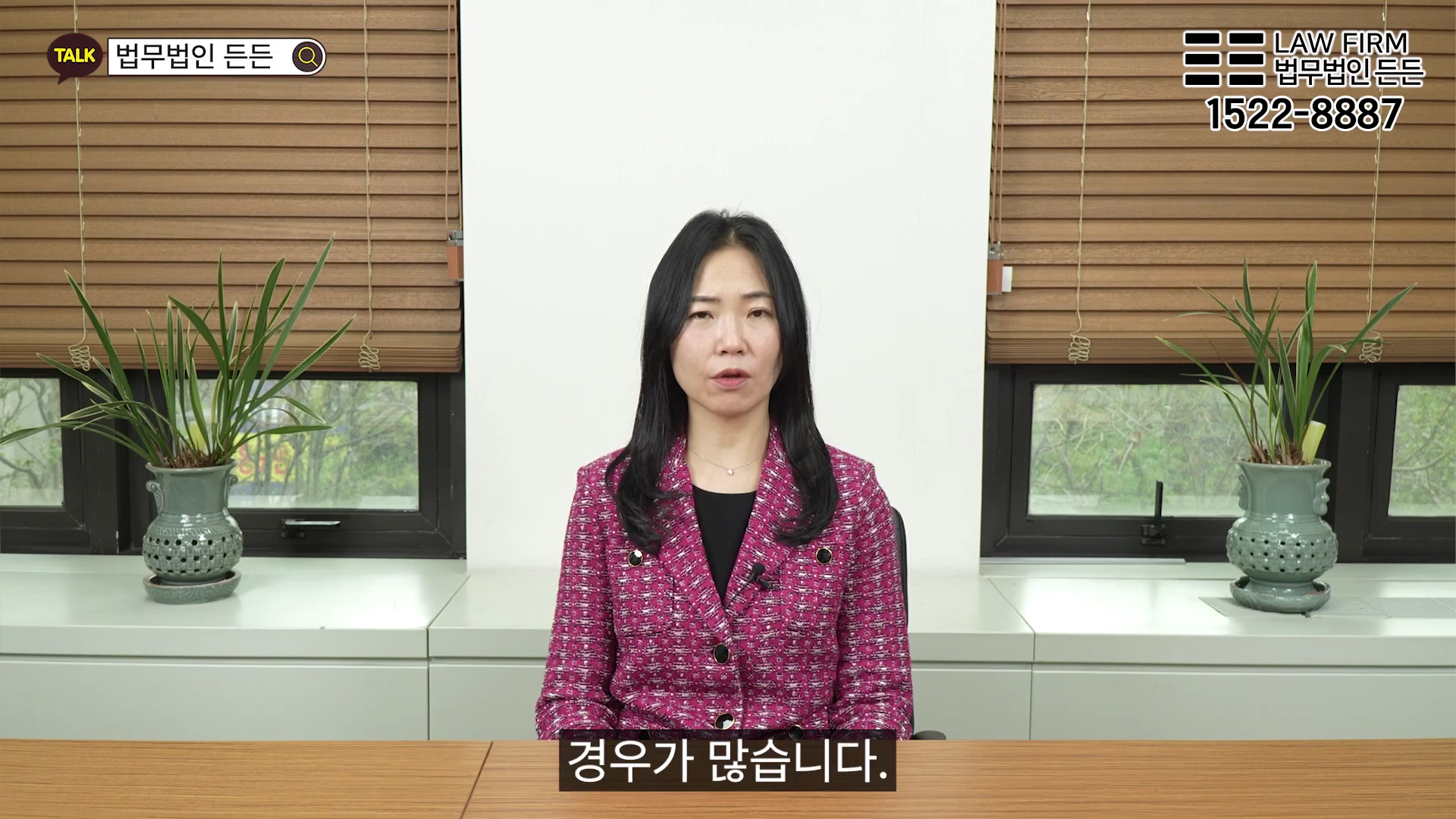 사무실 책상에 앉아 정면을 응시하며 이야기하는 여성 변호사의 모습