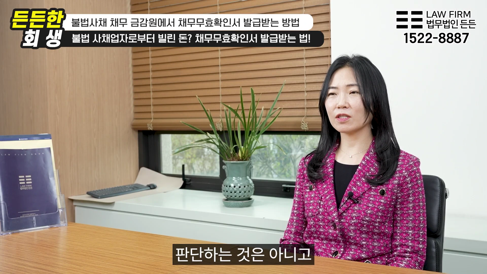 사무실 책상에 앉아 인터뷰 중인 여성과 그 옆에 놓인 법무법인 안내 책자