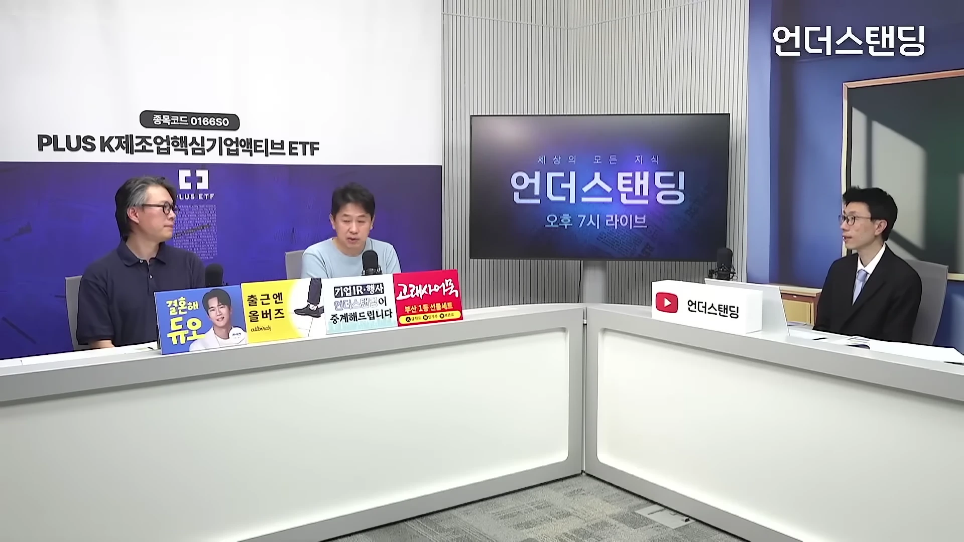 스튜디오에서 세 명의 남성이 책상 앞에 앉아 대화를 나누고 있는 모습