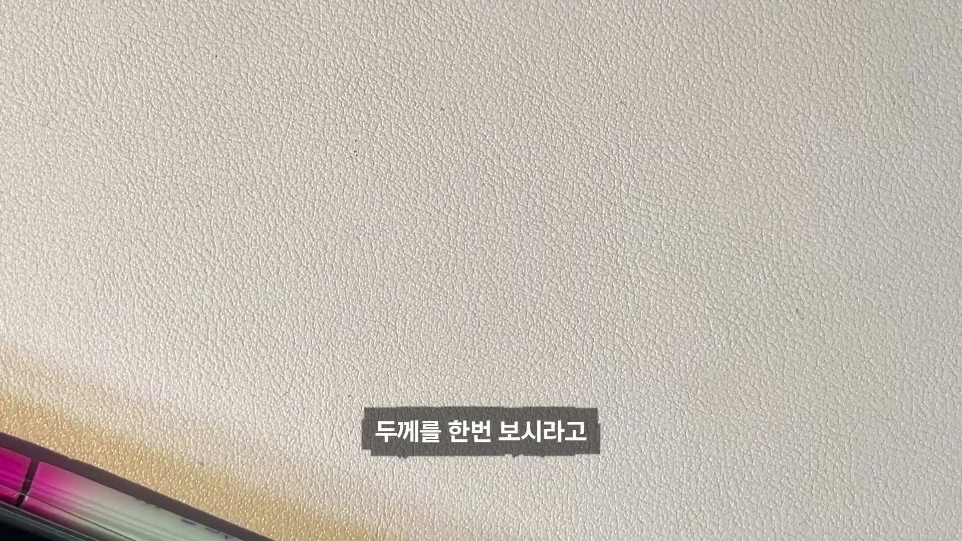 흰색 배경 위에 '두께를 한번 보시라고'라는 자막이 적힌 영상 화면