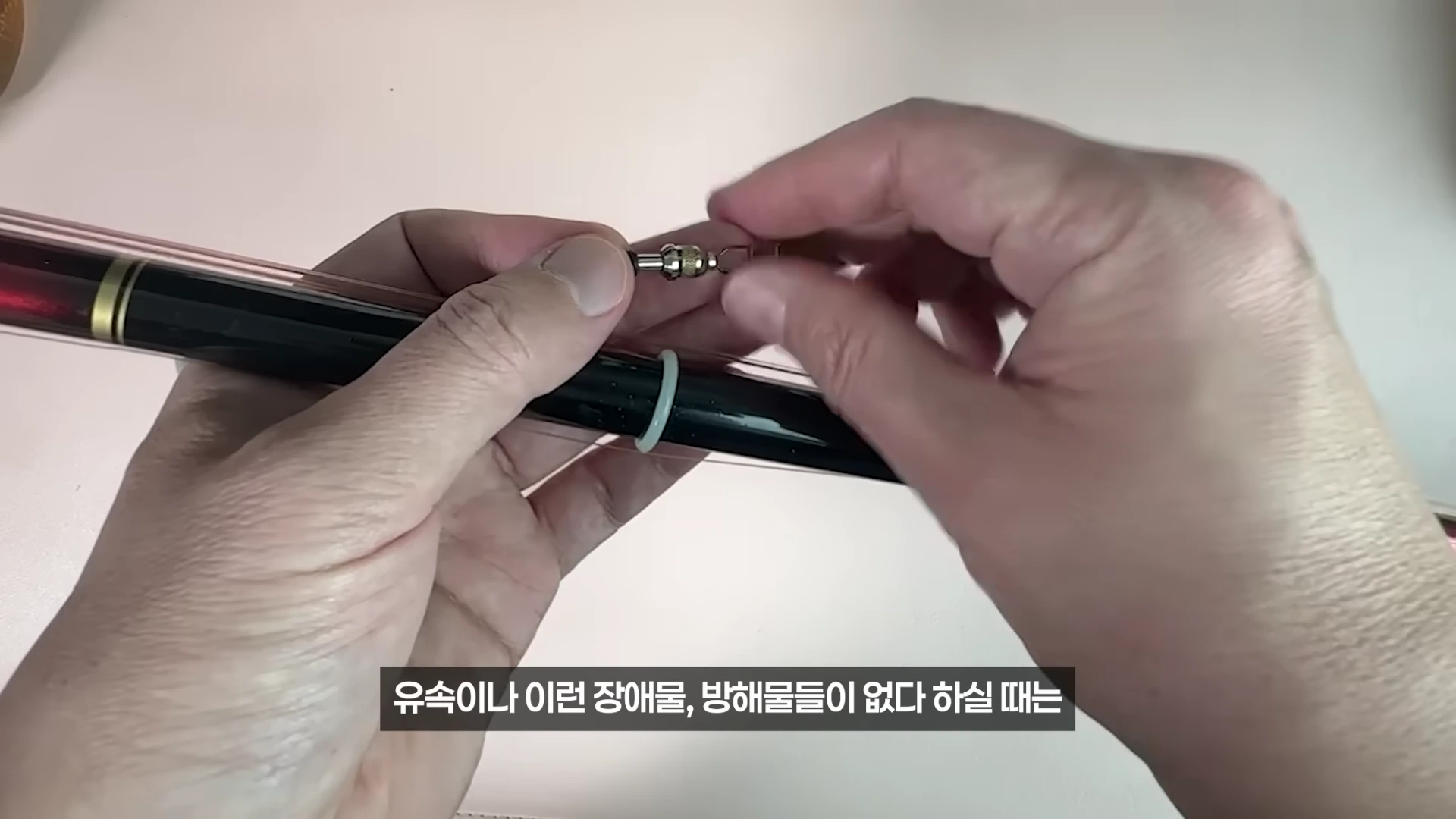 낚시 채비의 도래와 멈춤고무를 손으로 조절하는 모습