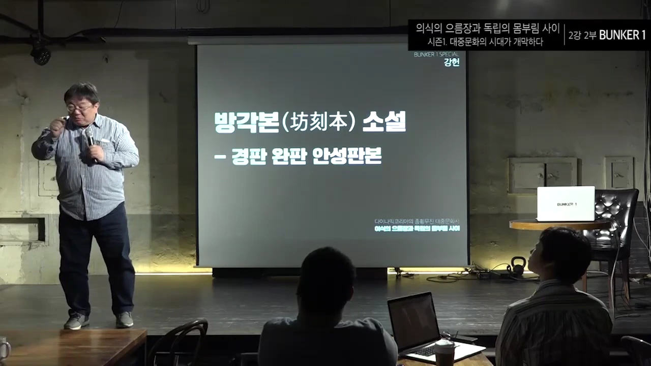 강연자가 무대 위 스크린에 '방각본 소설'이라는 제목이 적힌 발표 자료를 띄워놓고 청중 앞에서 이야기하고 있다.