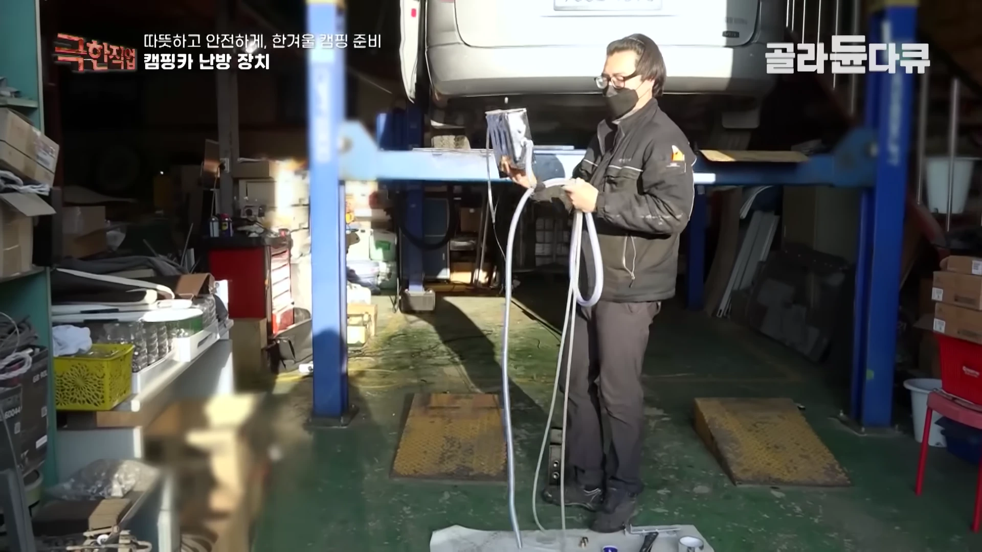 정비소에서 작업자가 온수 매트용 호스를 연결하고 있는 모습