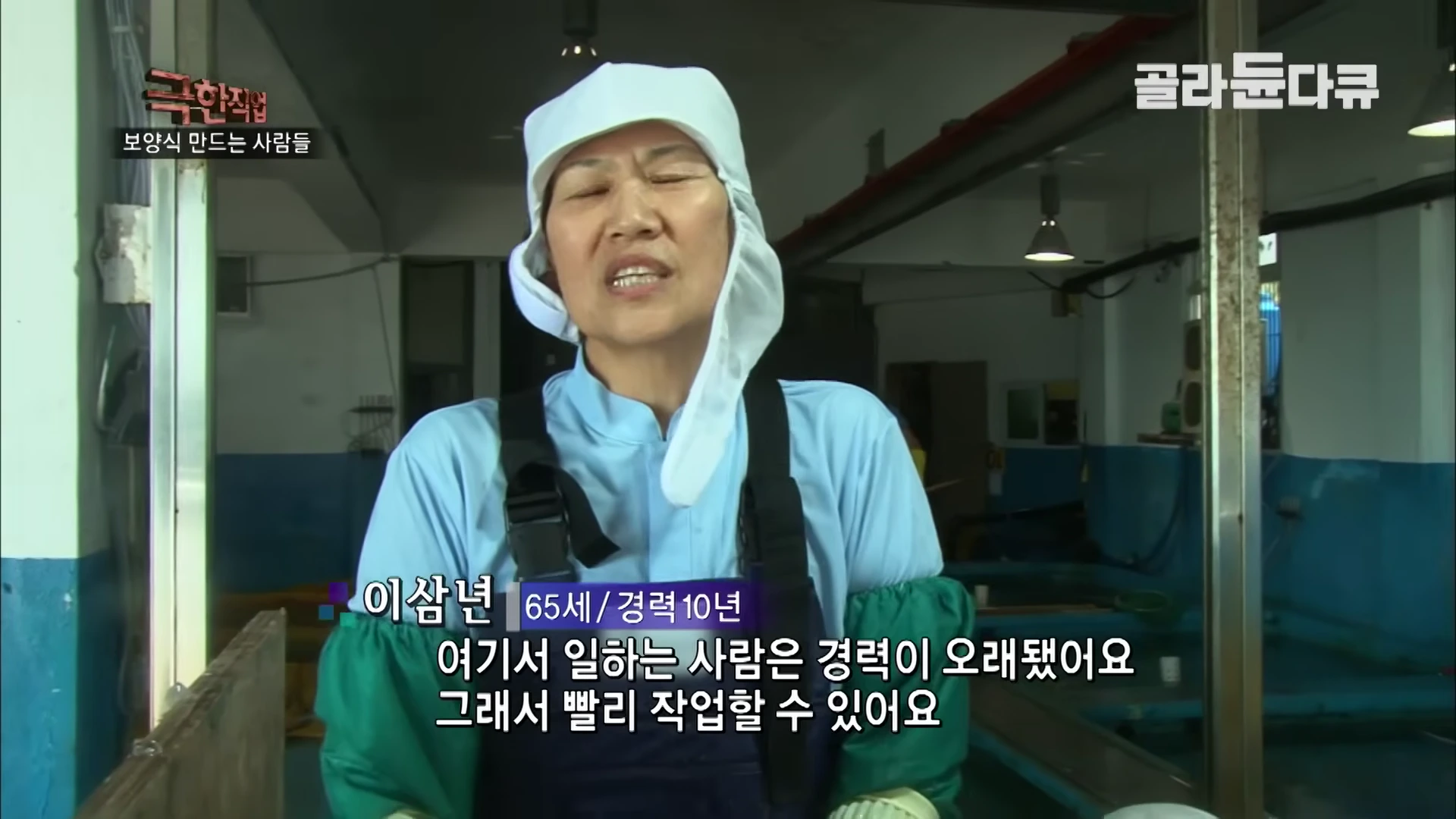 위생모와 작업복을 착용한 중년 여성이 공장에서 인터뷰하고 있는 모습