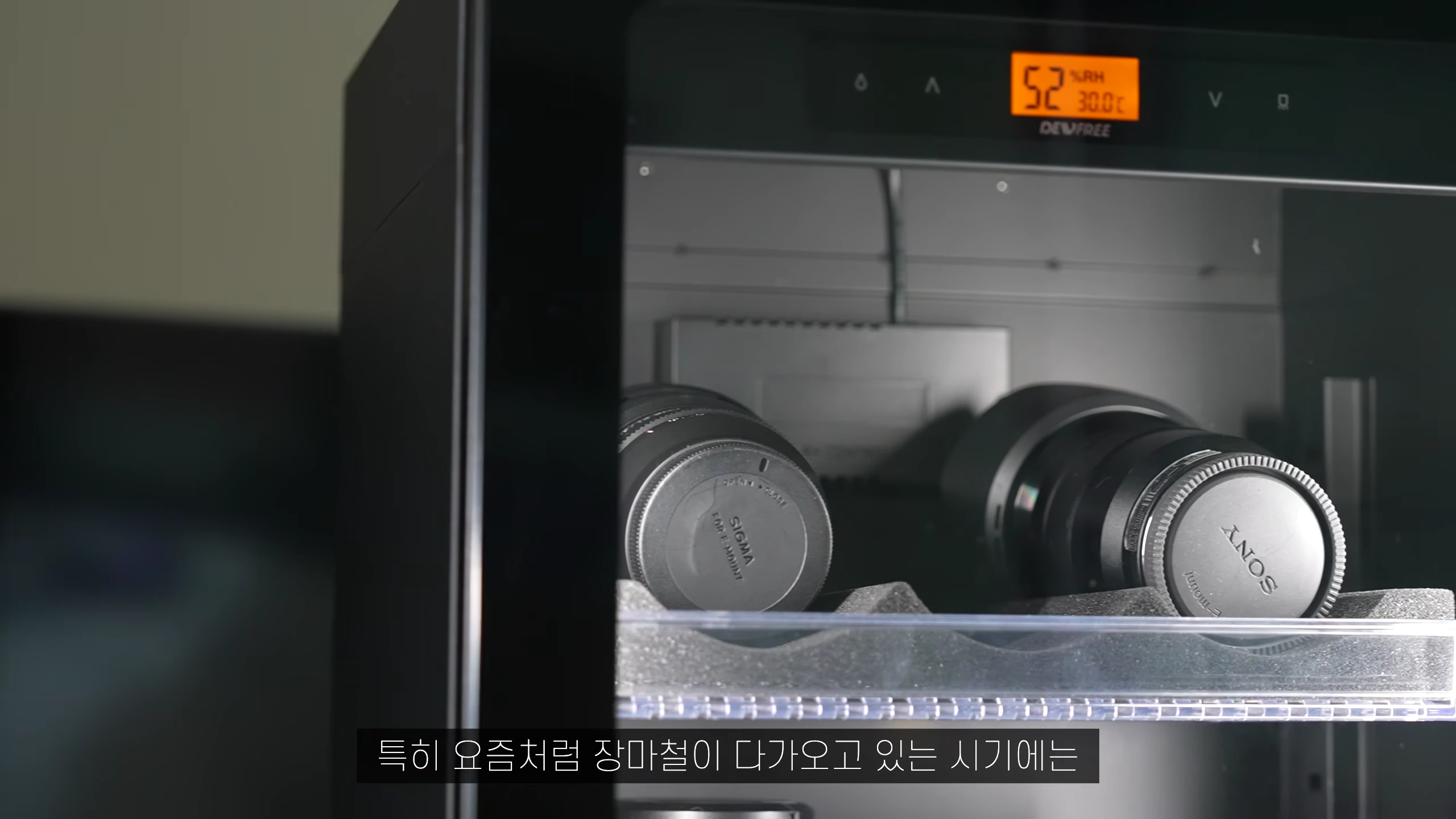 카메라 렌즈들이 보관된 제습함 내부와 습도 및 온도가 표시된 디지털 디스플레이