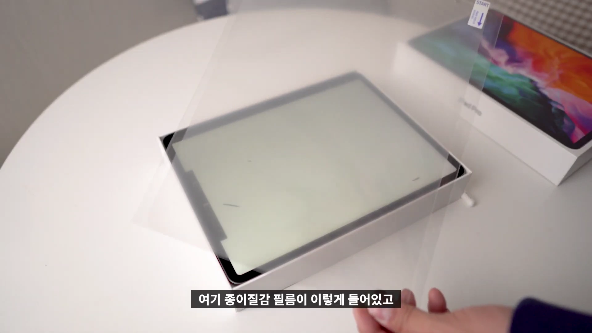 아이패드 프로 위에 종이 질감 필름을 덮어 부착을 준비하는 모습