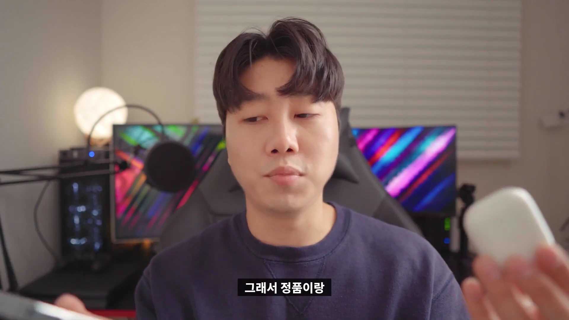 스튜디오에서 이어폰 케이스를 들고 설명하는 남성