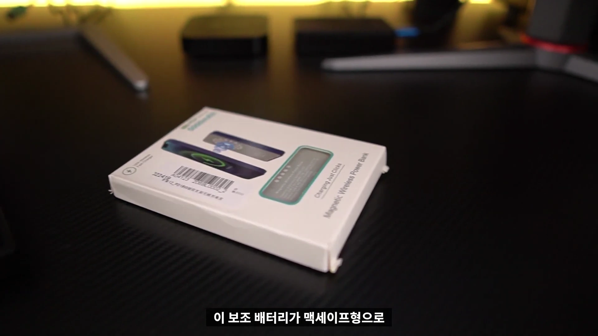 검은색 책상 위에 놓인 맥세이프 보조배터리 제품 패키지 상자