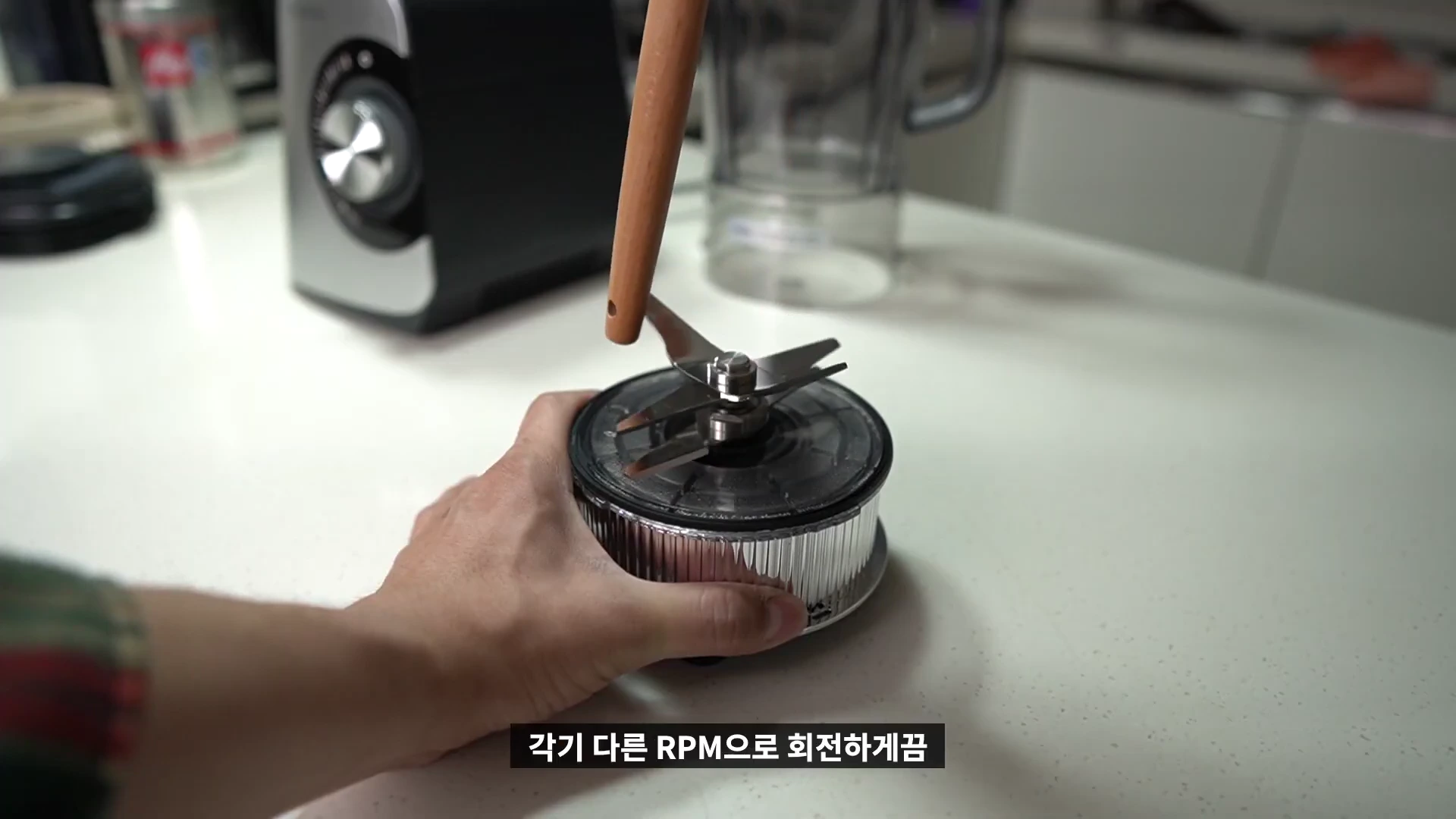 사람의 손이 블렌더의 상하 이중 칼날 부품을 잡고 있는 모습
