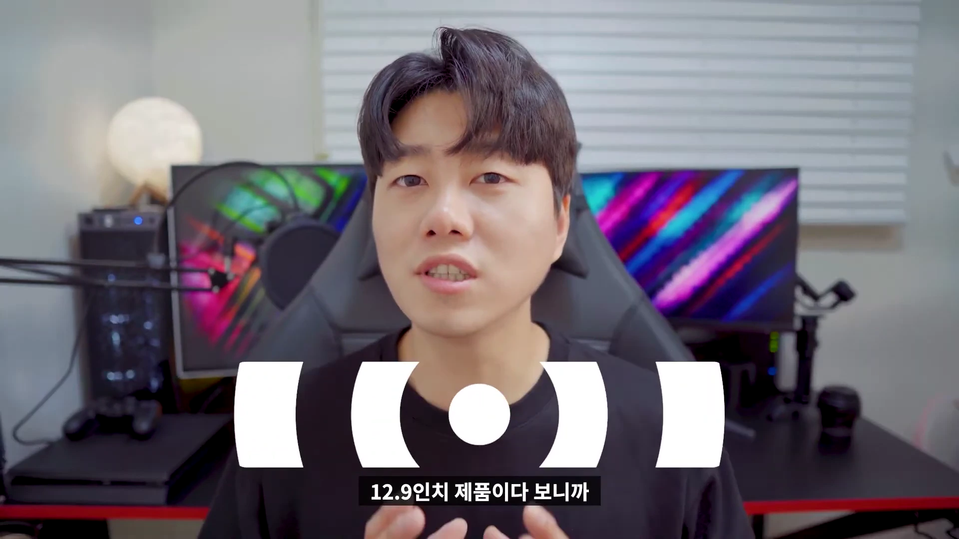 실내 책상 앞에 앉아 카메라를 응시하며 이야기하는 남성