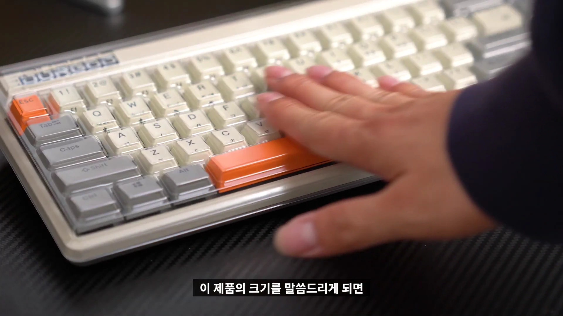 레트로한 디자인의 기계식 키보드 위에 손을 올려 크기를 가늠하는 모습